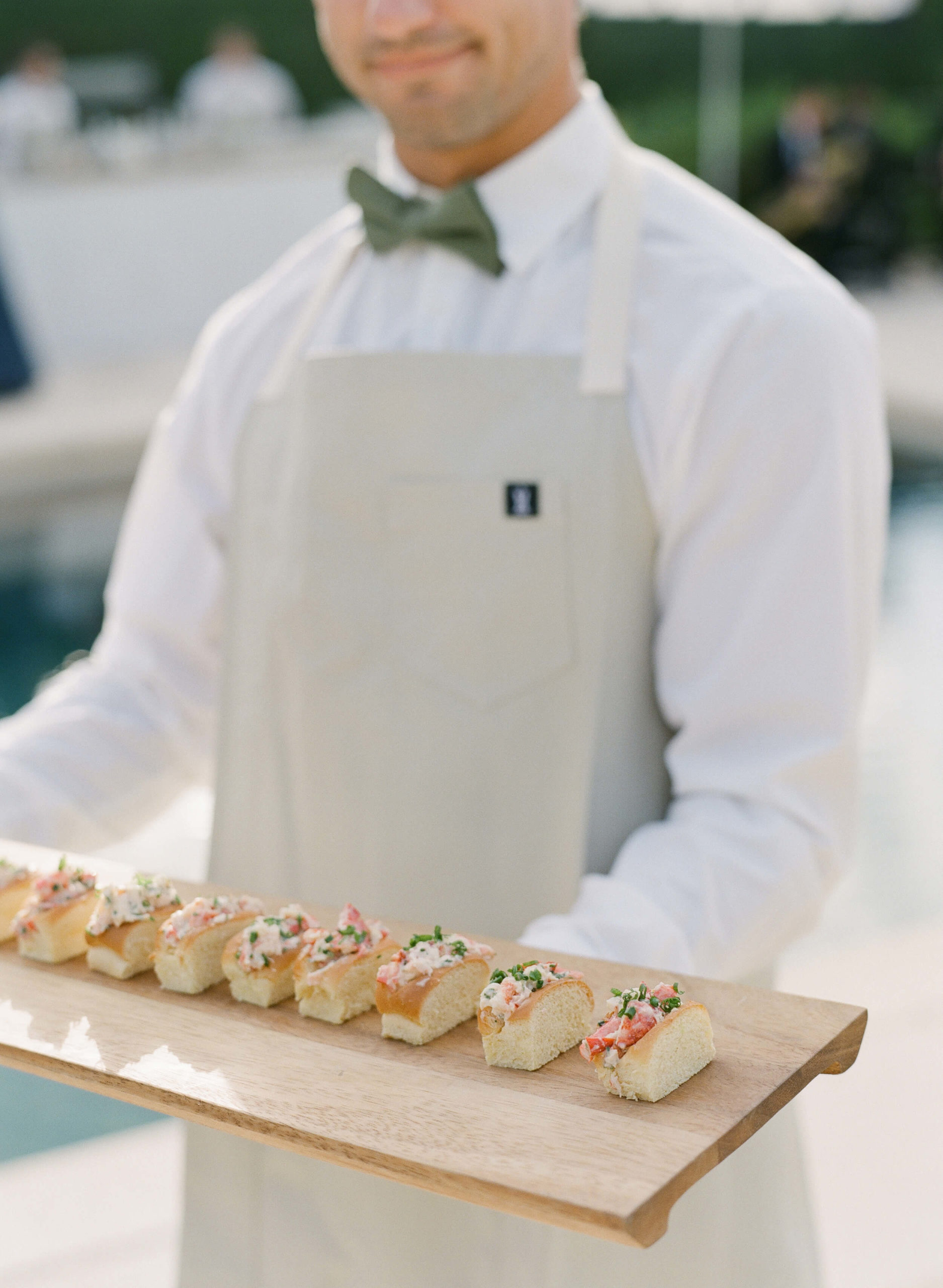 mini lobster rolls on wooden serving tray