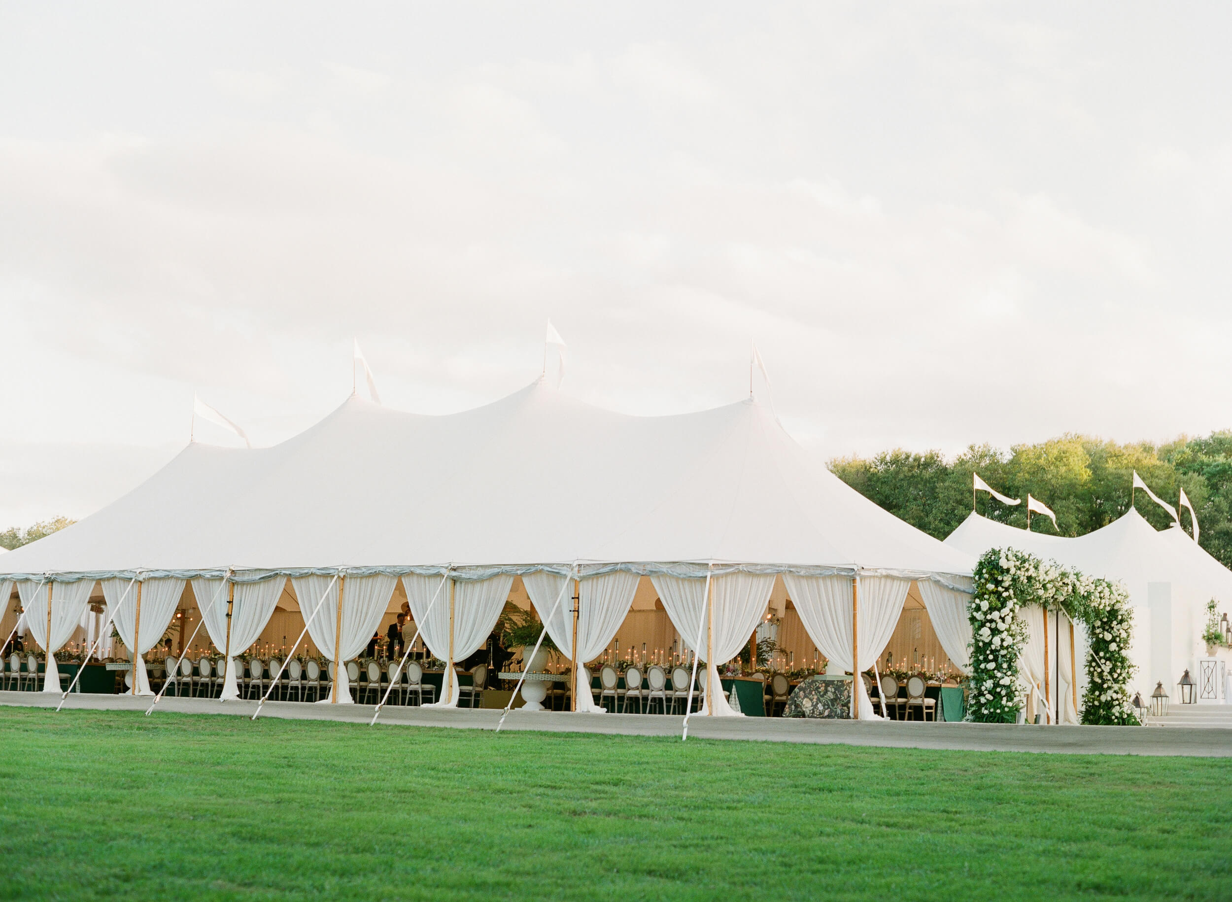 a white tent with formal dinner service