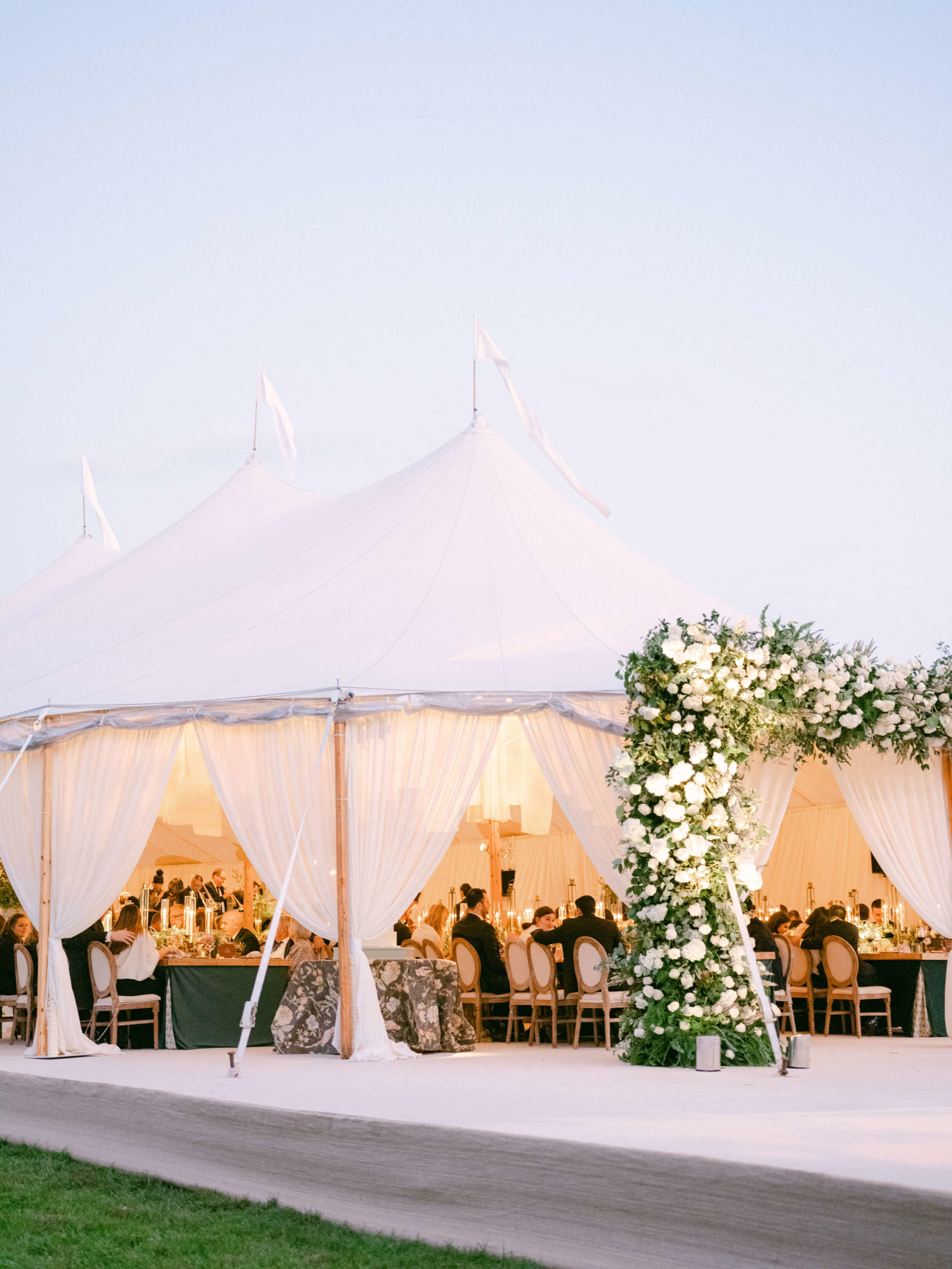 guests enjoy dinner under white tent at Tampa wedding