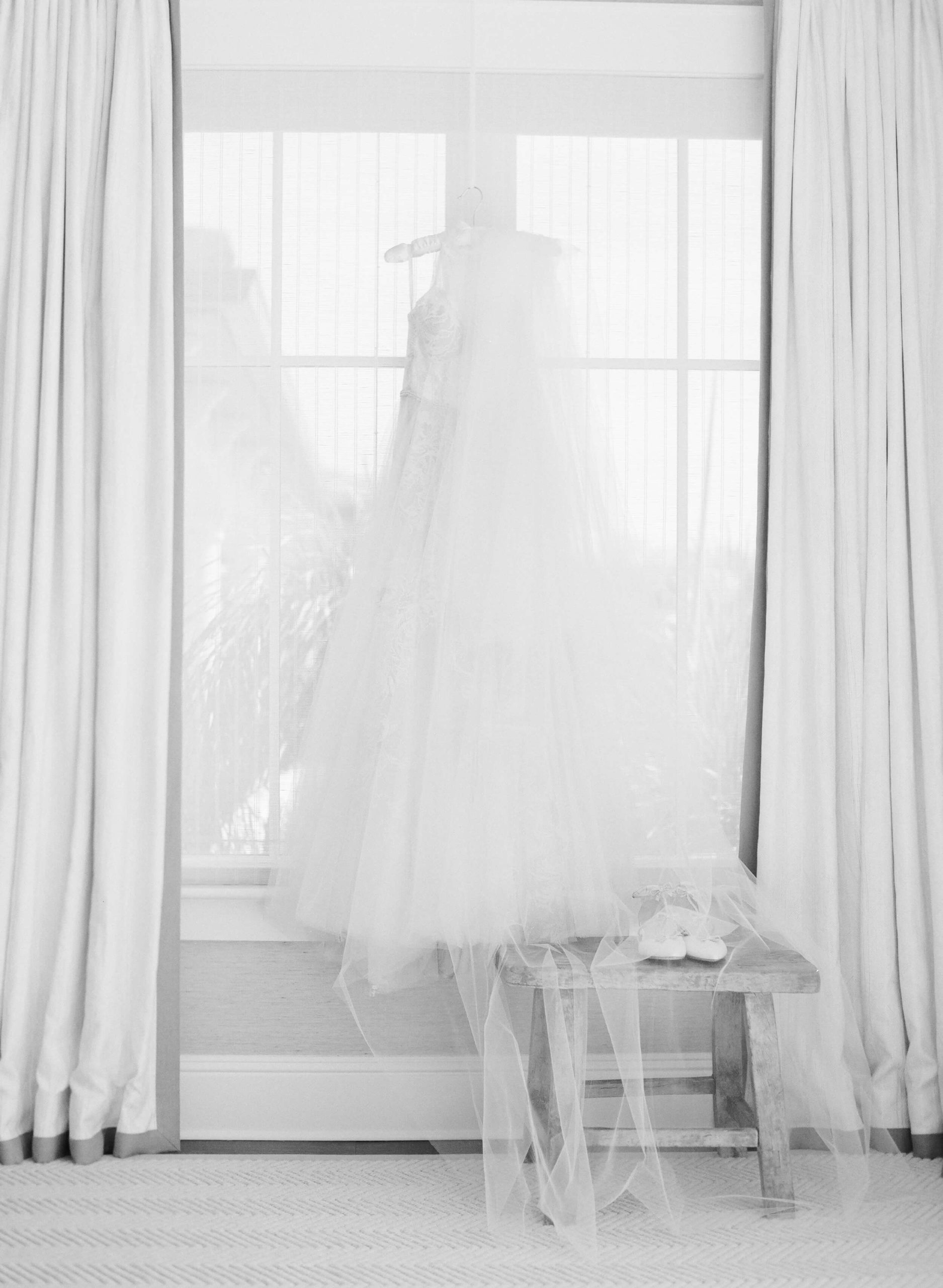 wedding gown hanging in a window