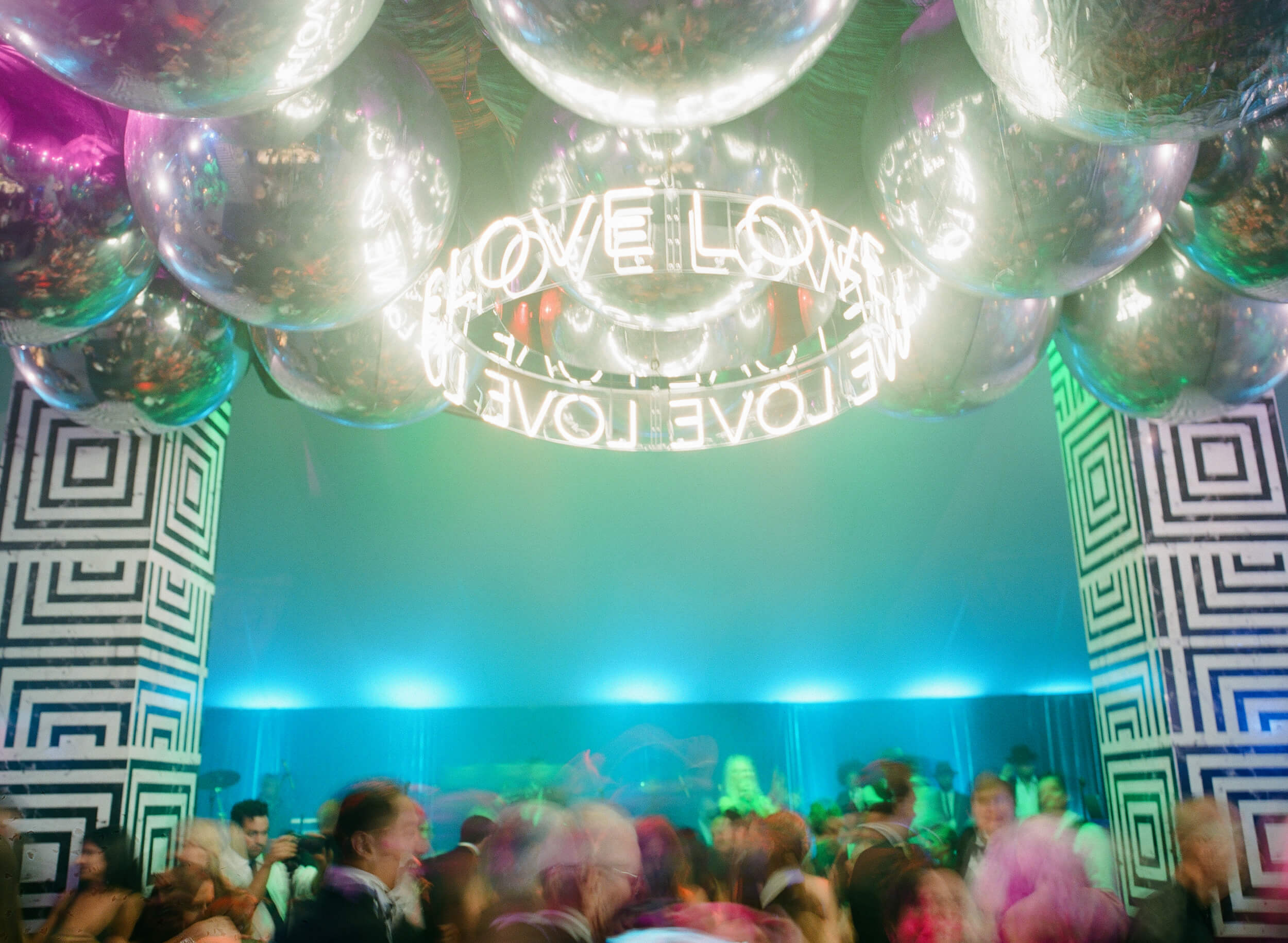 colorful lights and disco balls decorate the dance party reception