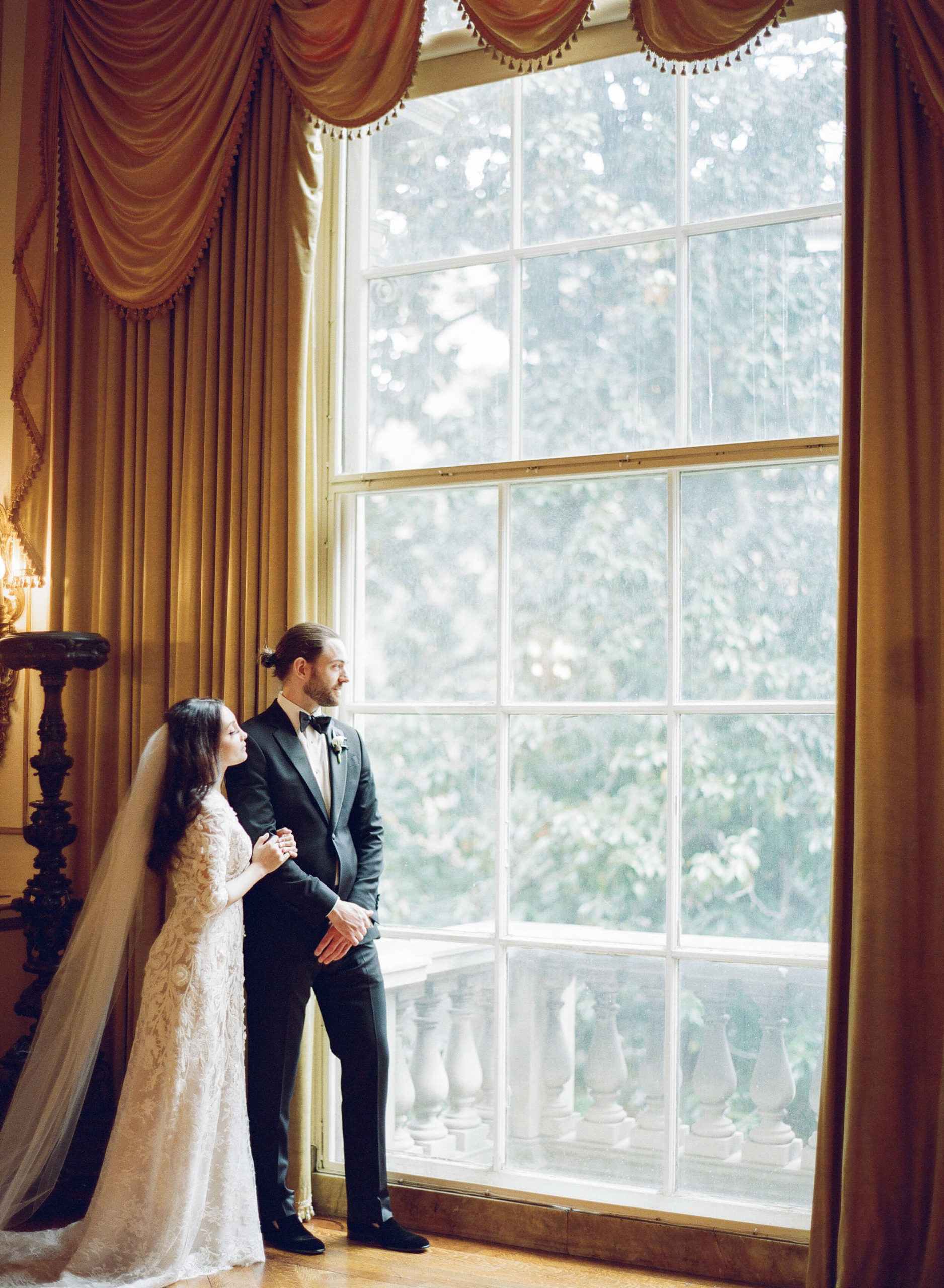 bride and groom at window of Anderson House