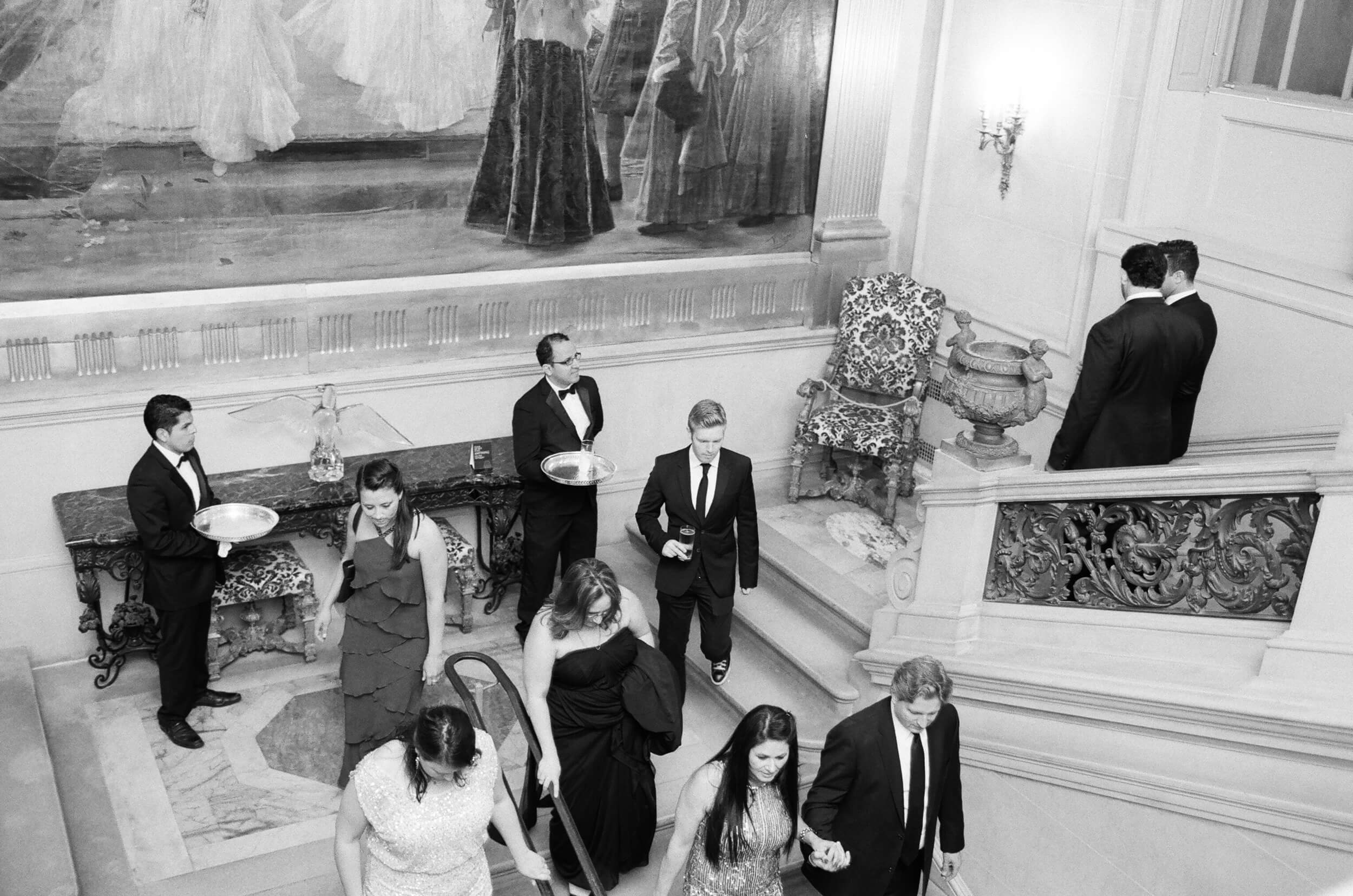 wedding guests descend staircase at Anderson House