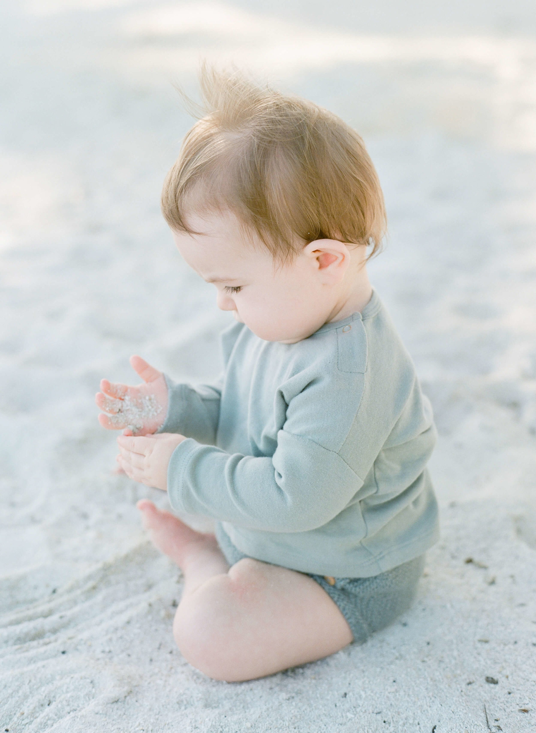 little boy plays in sand at family portraits in Islamorada Florida