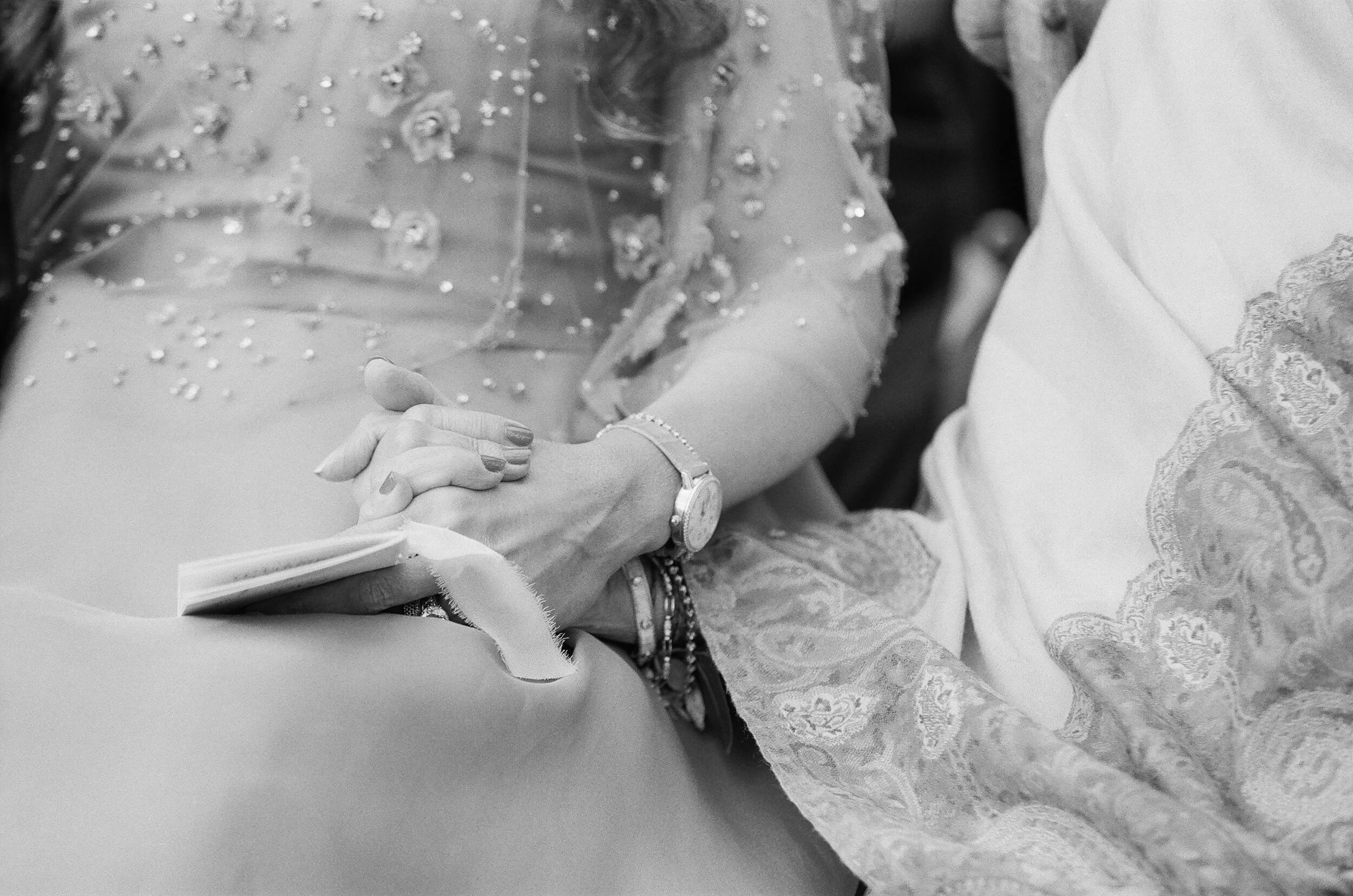 guests hold hands at wedding ceremony