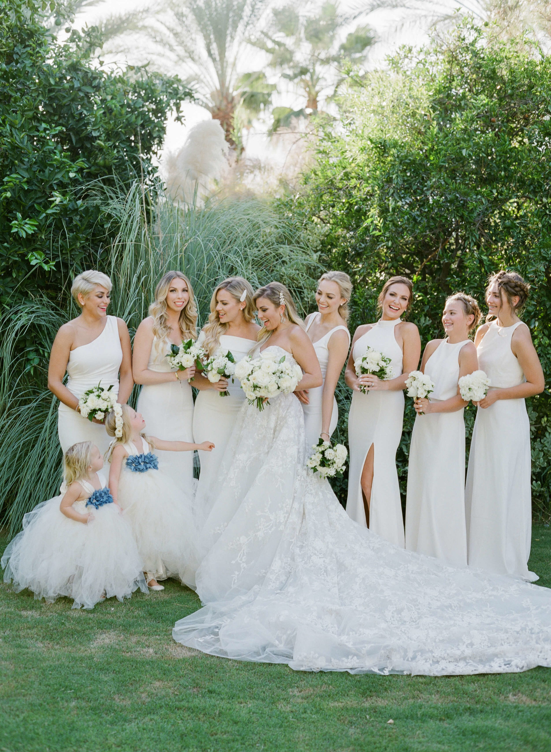 bridal party in white gowns with flower girls