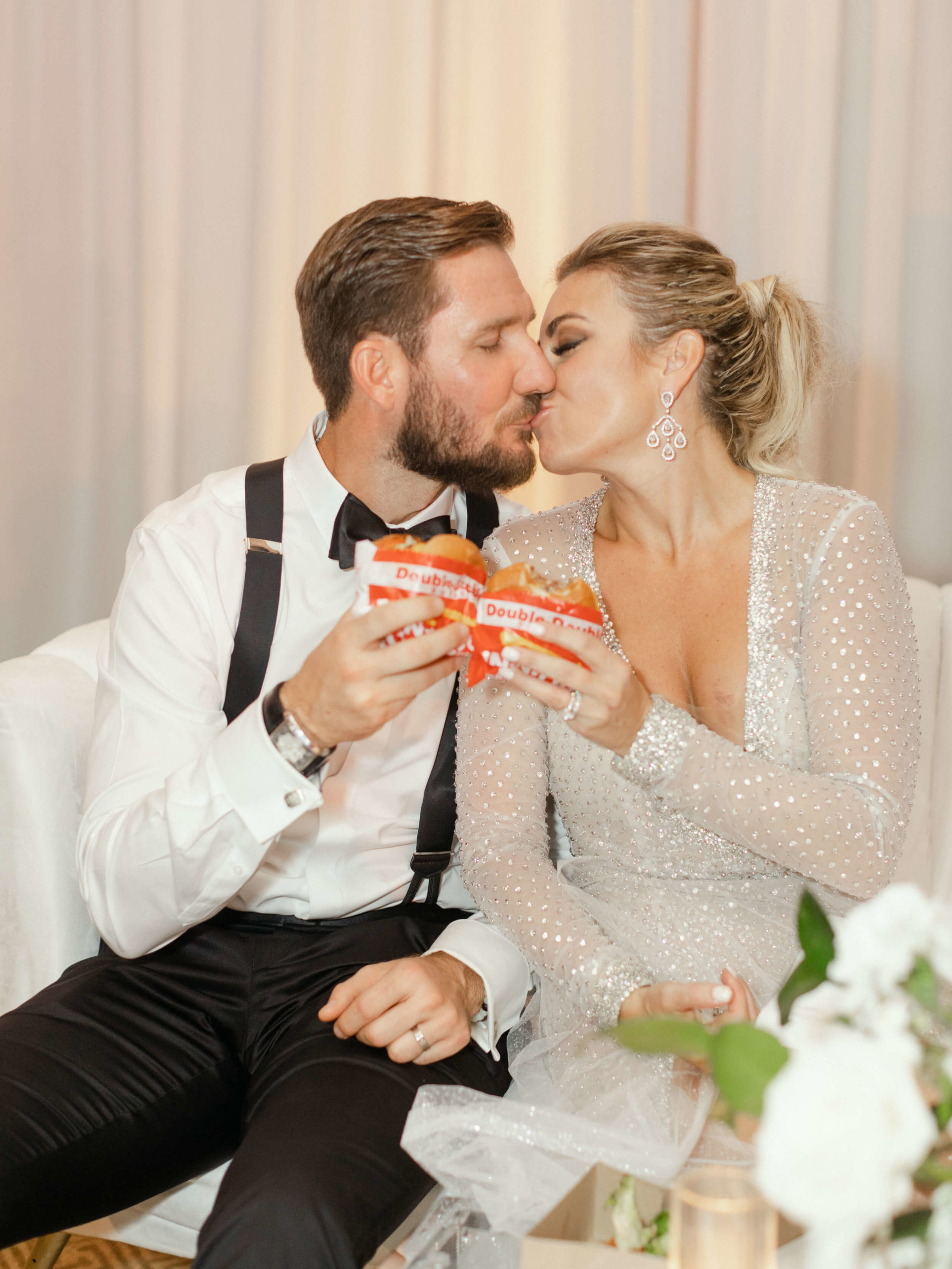 bride and groom kiss with In-n-Out cheeseburgers