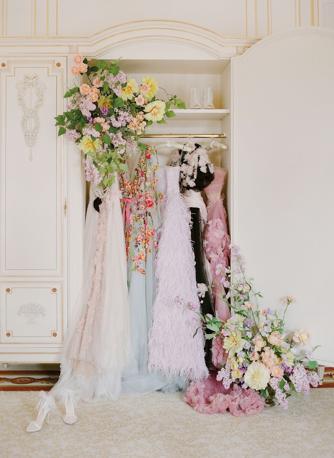 feminine bridal gowns hanging in Paris closet