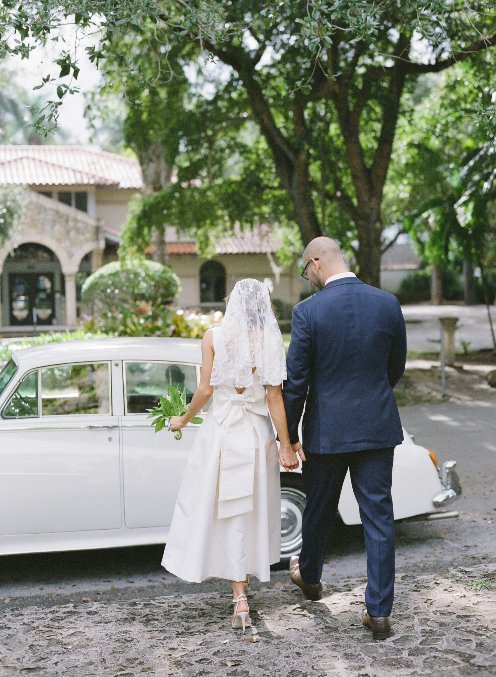 Bride and groom walking to their getaway car after their Miami wedding ceremony.