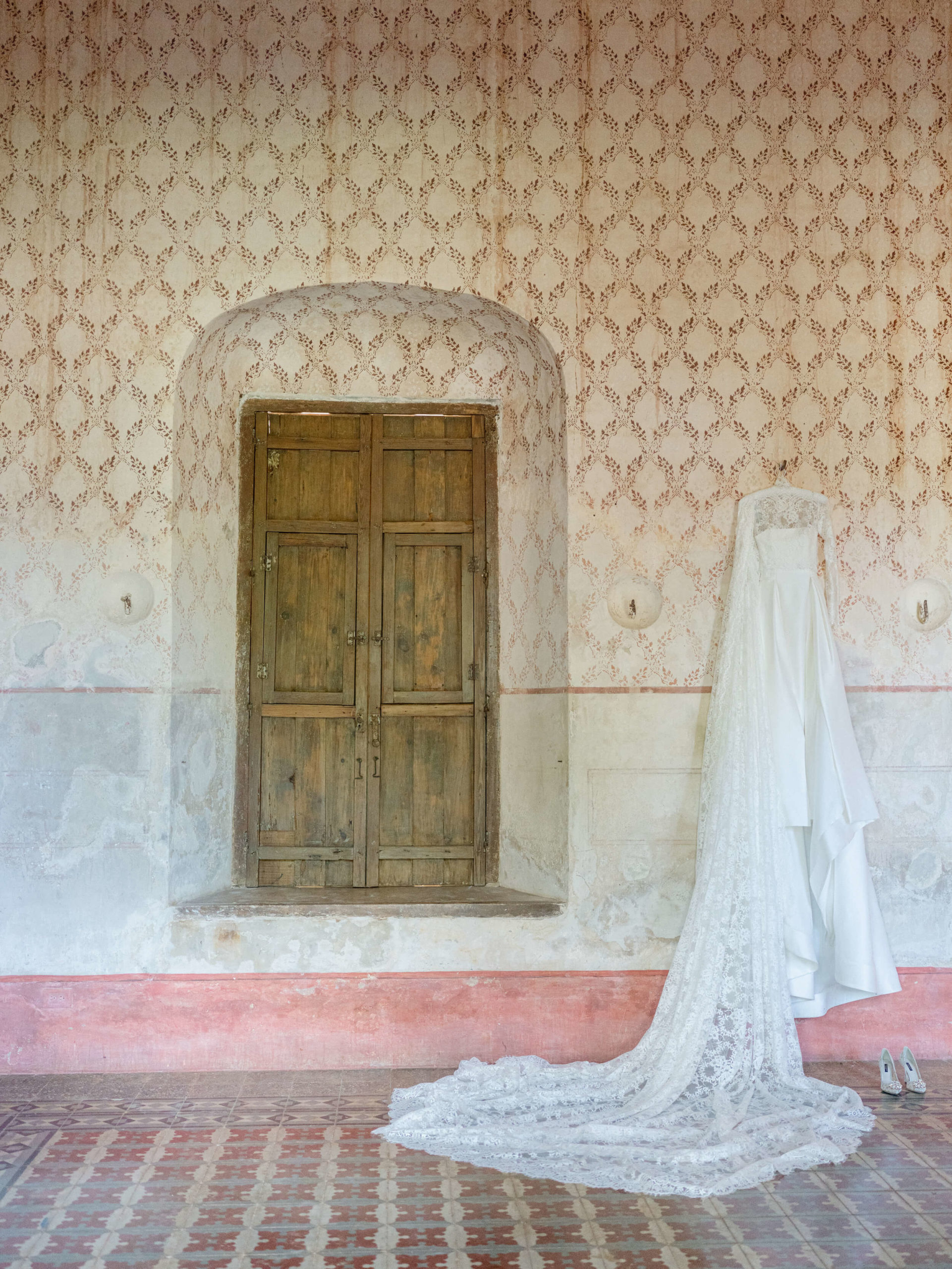 Bride's dress hung up on wall of historical hacienda