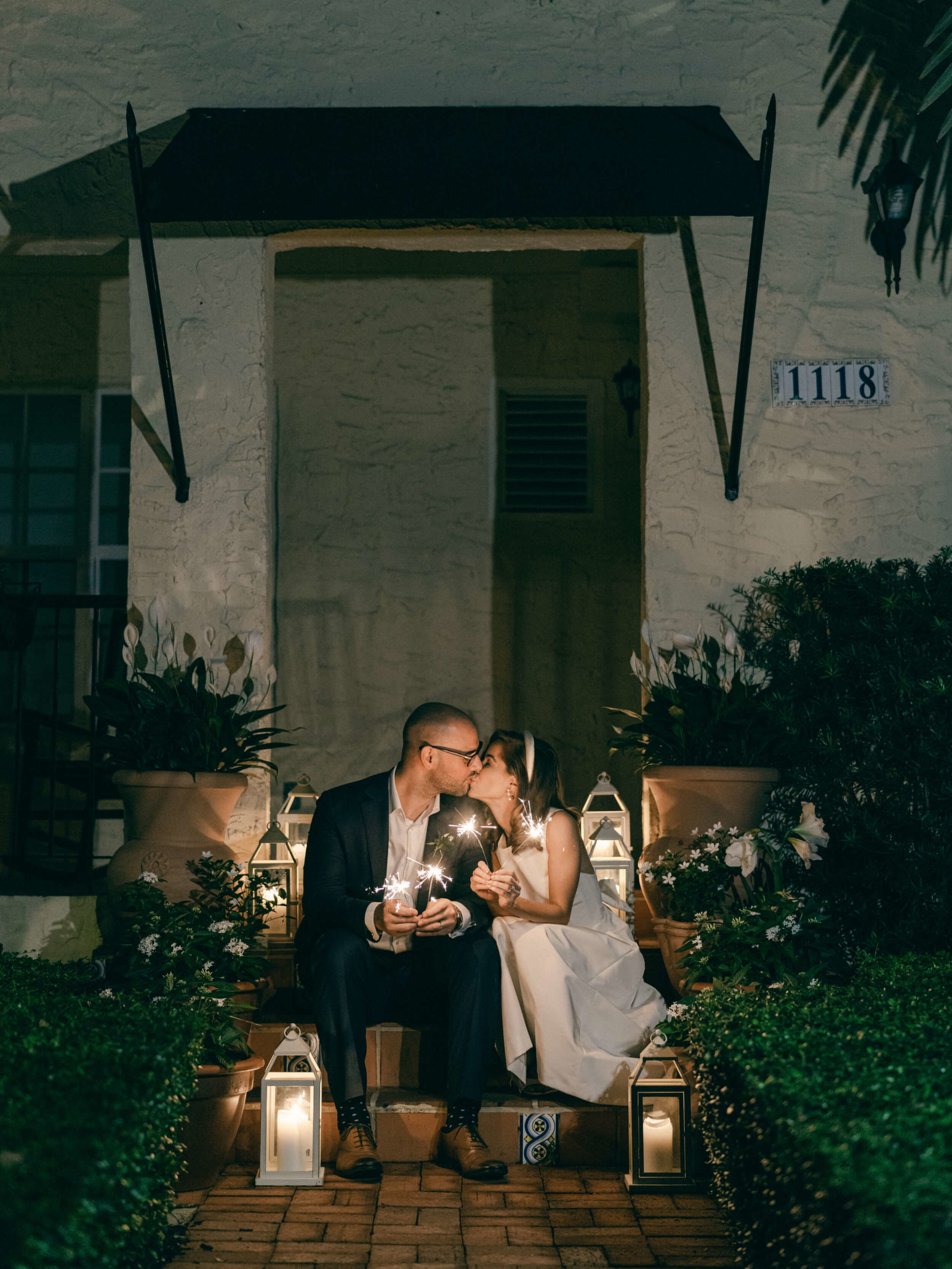Bride and groom kissing with sparklers in front of their Miami home