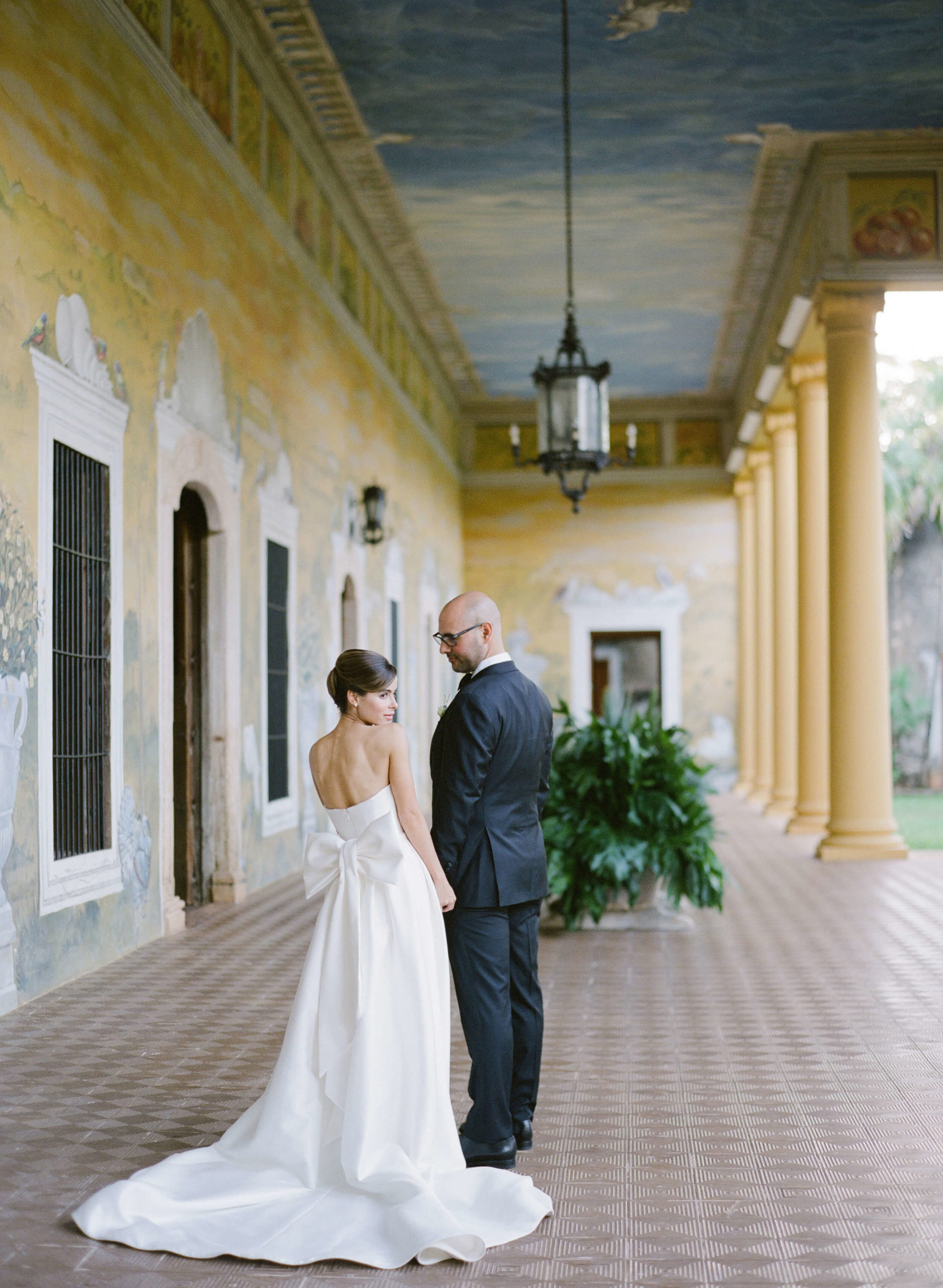 Bride and groom pose in historic hacienda