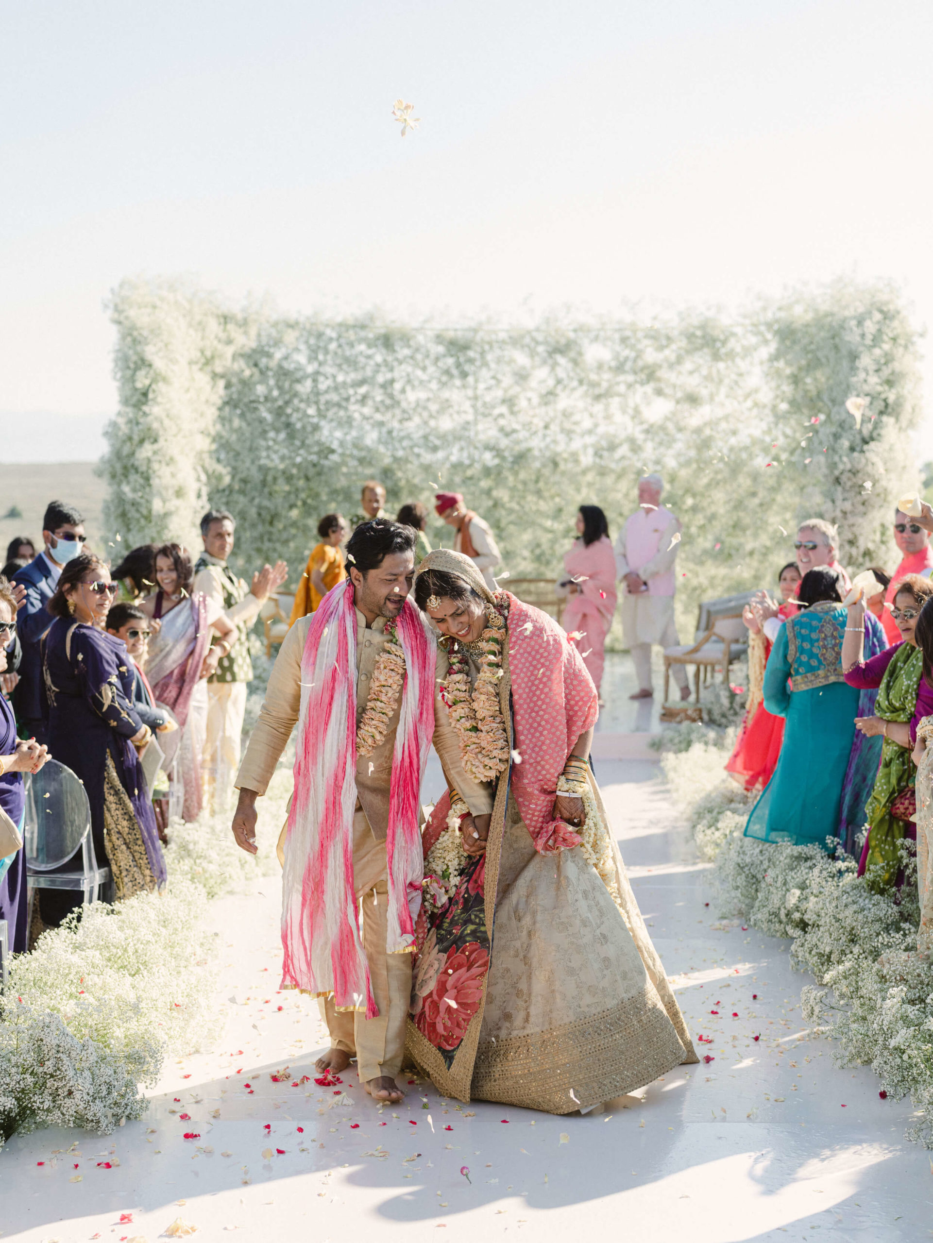 Sapna and Ari walking down the aisle at their Indian wedding