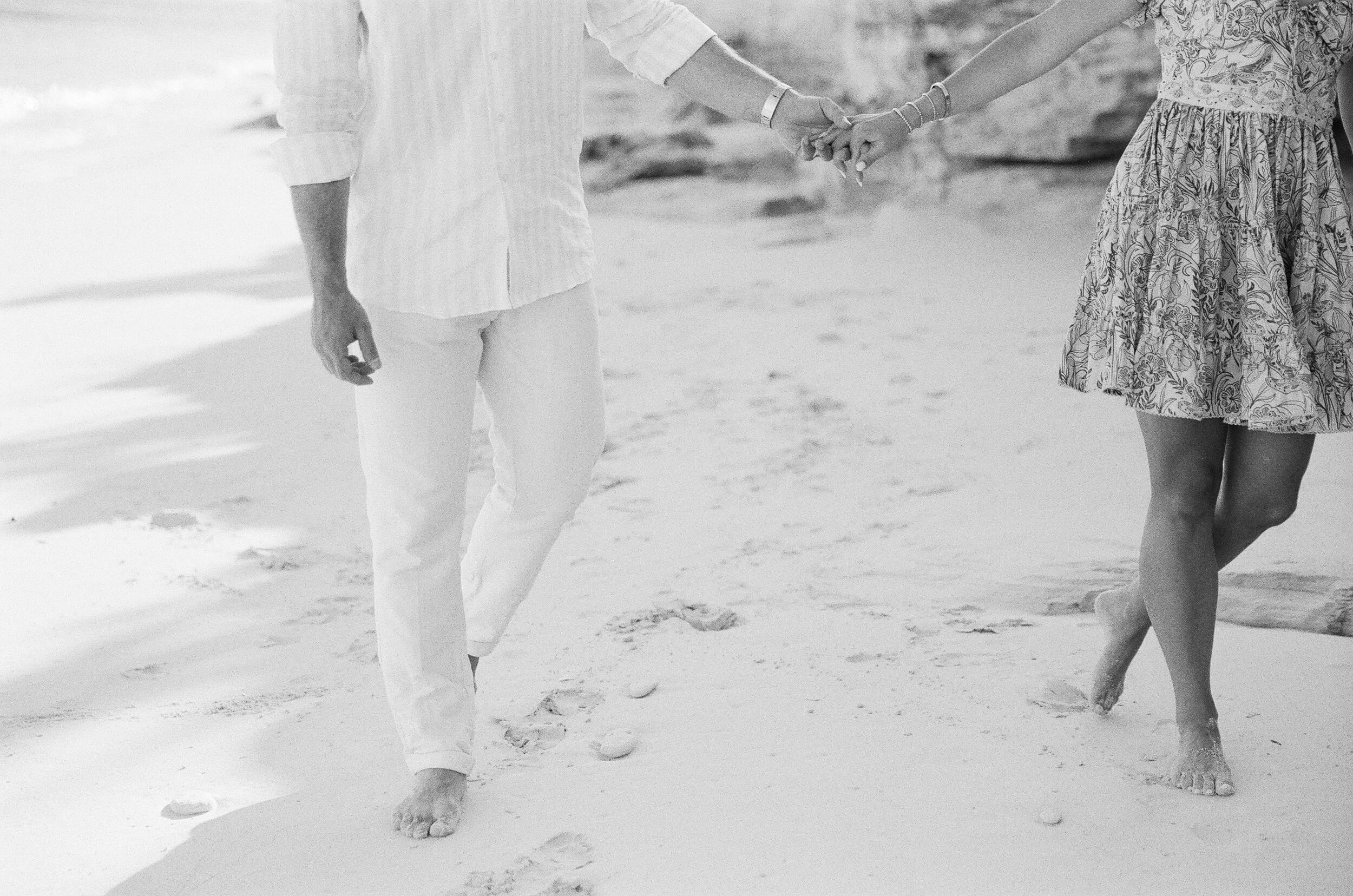 Liz and Dave holding hands on the beach