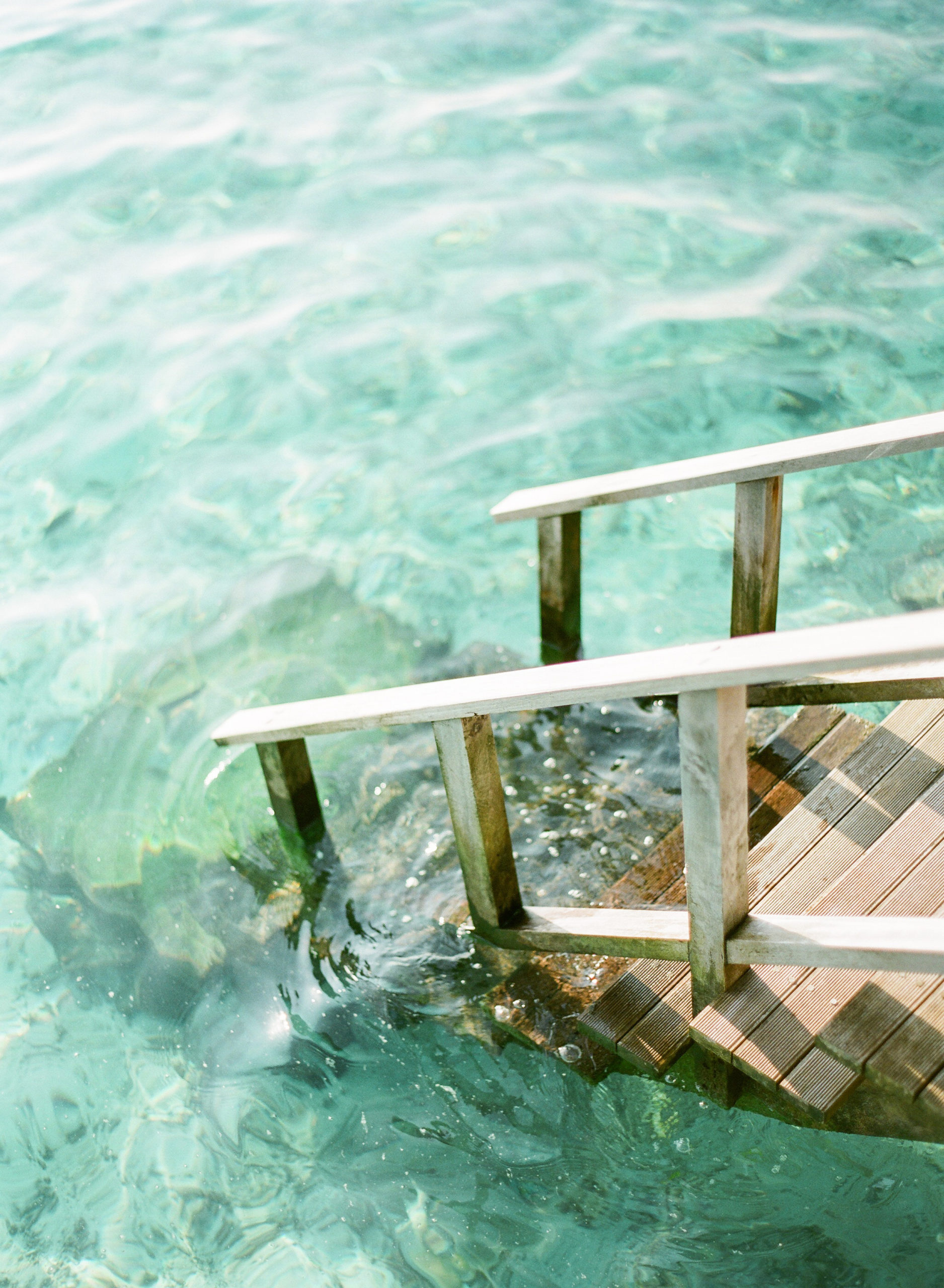 Wooden ladder descending into water; Maldives