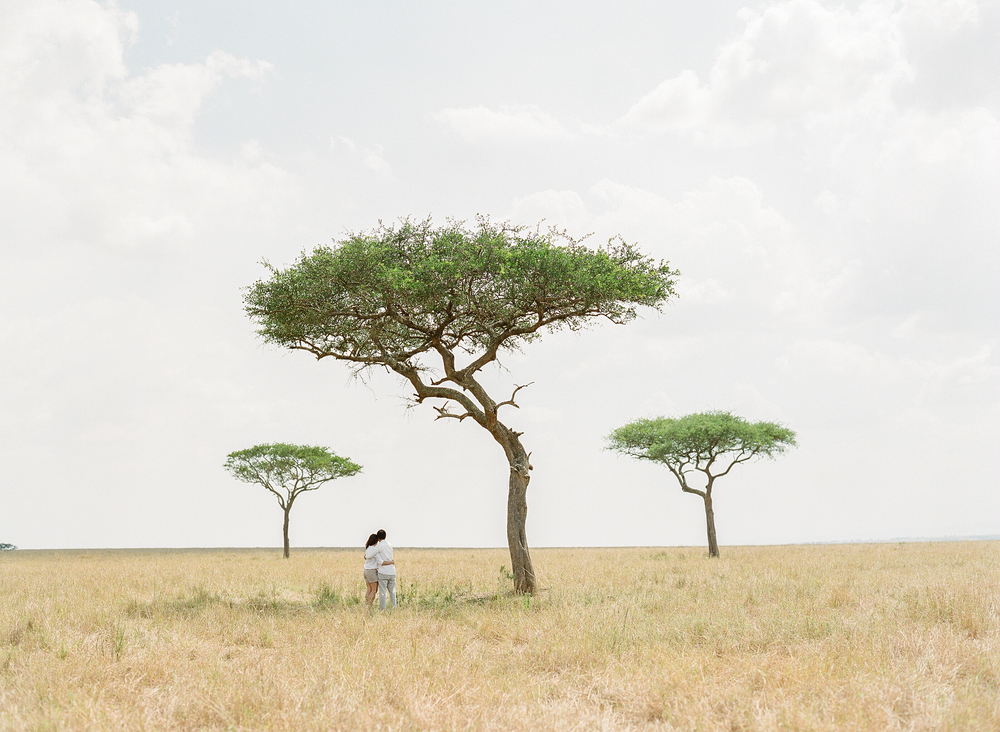 Couple embracing under trees in Serengeti, Africa
