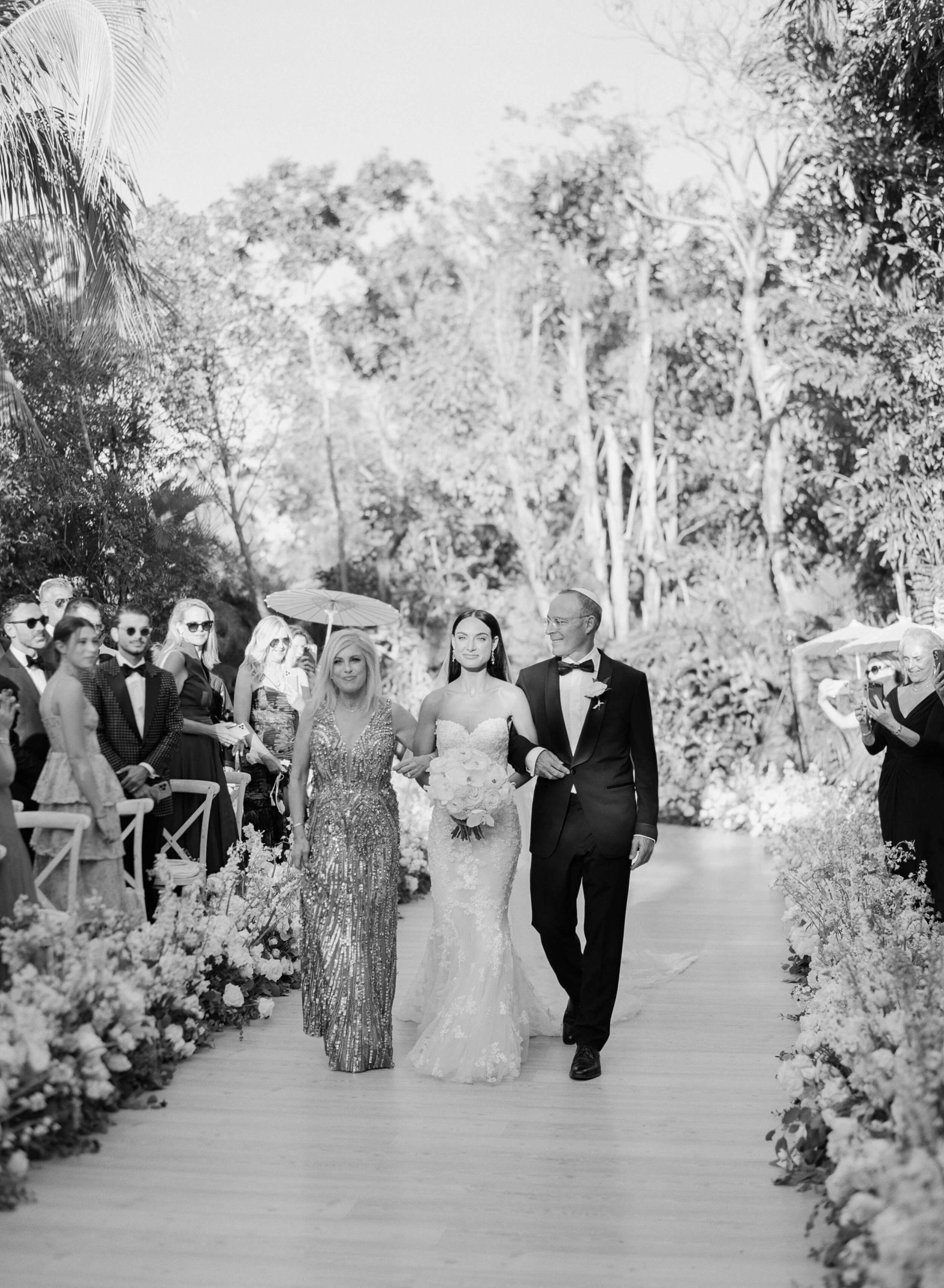 Danielle's parents walking her down the isle at her Rosewood Mayakoba wedding