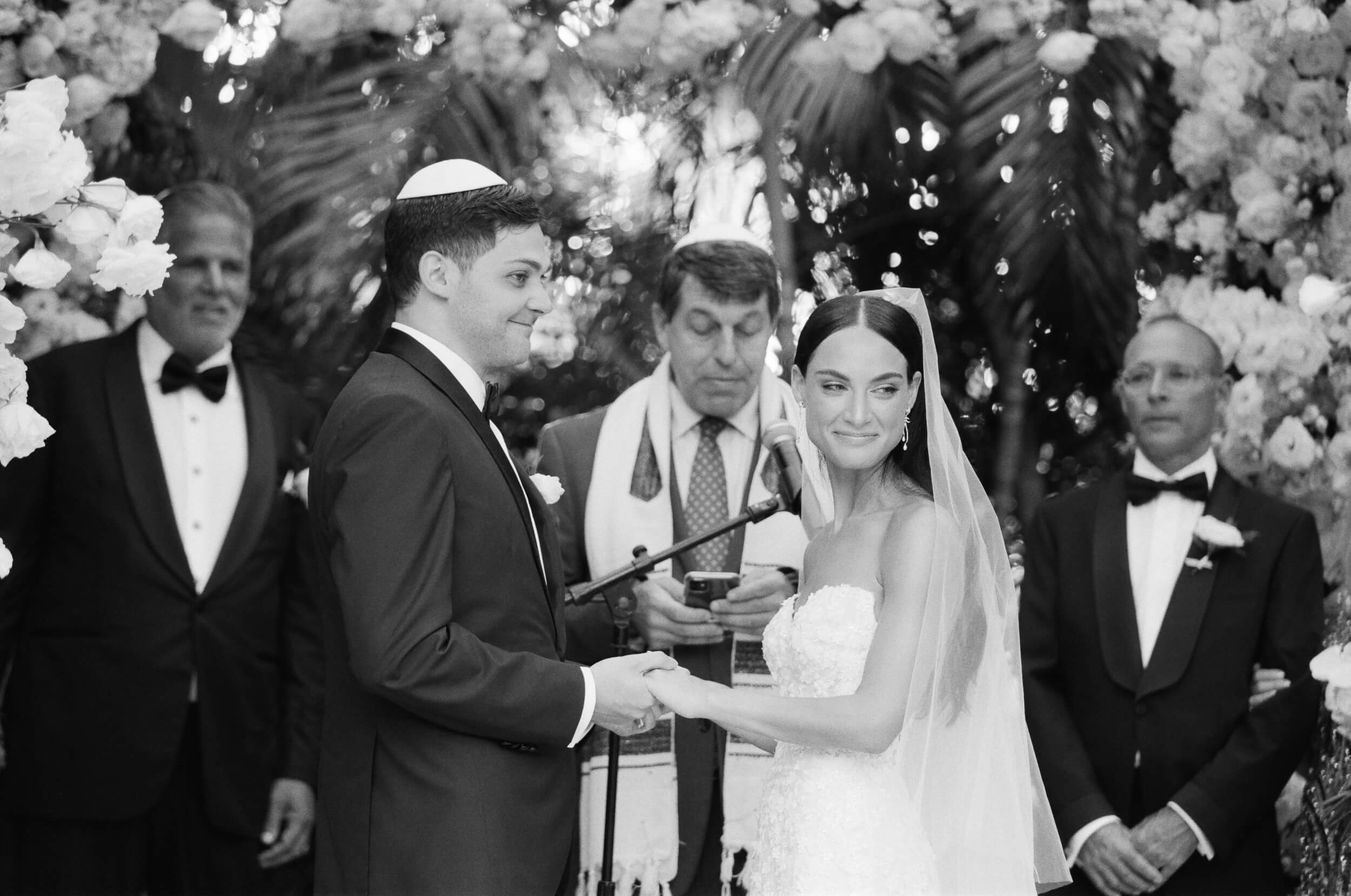 Danielle and Lucas smiling at their guests at the altar
