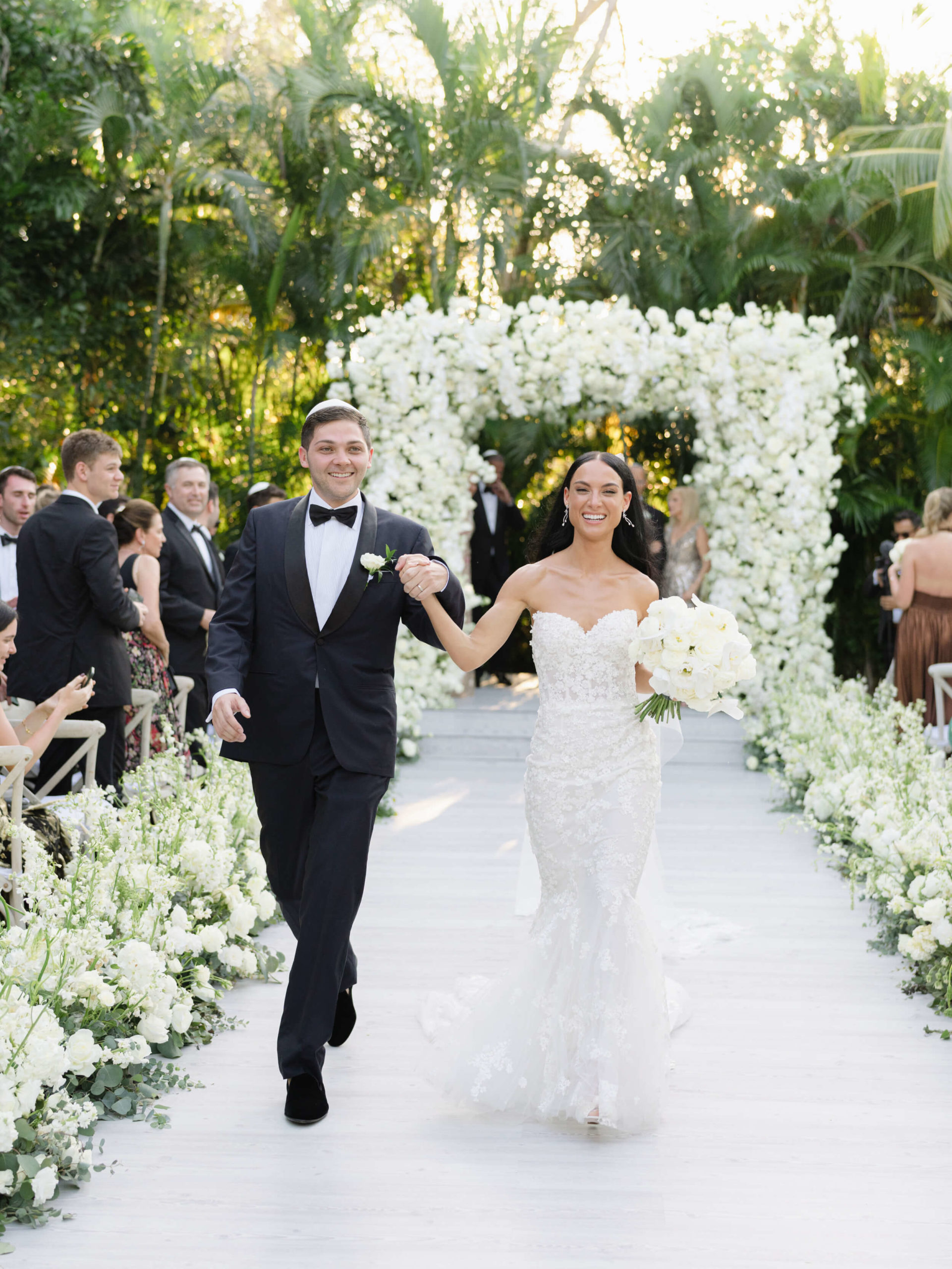 Danielle and Lucas smiling hand in hand as they walk down the isle after officially marrying