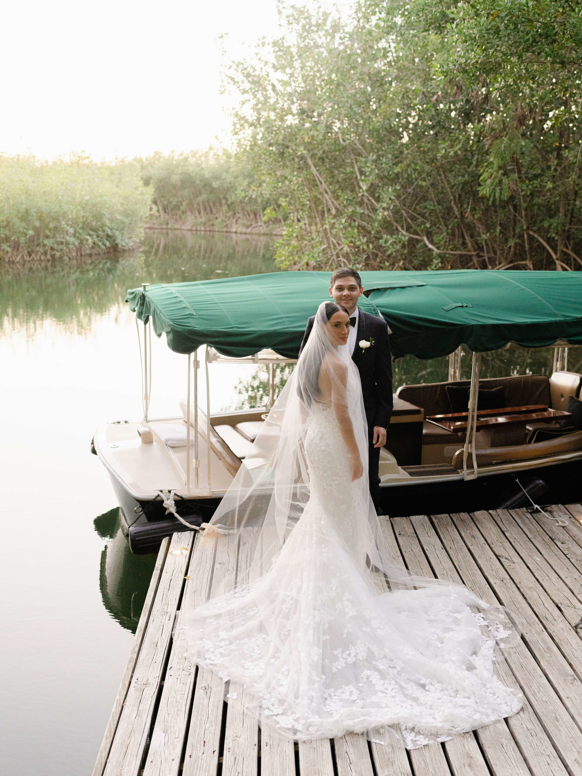 Danielle and Lucas boarding a boat on a river at the Rosewood Mayakoba Resort after their wedding