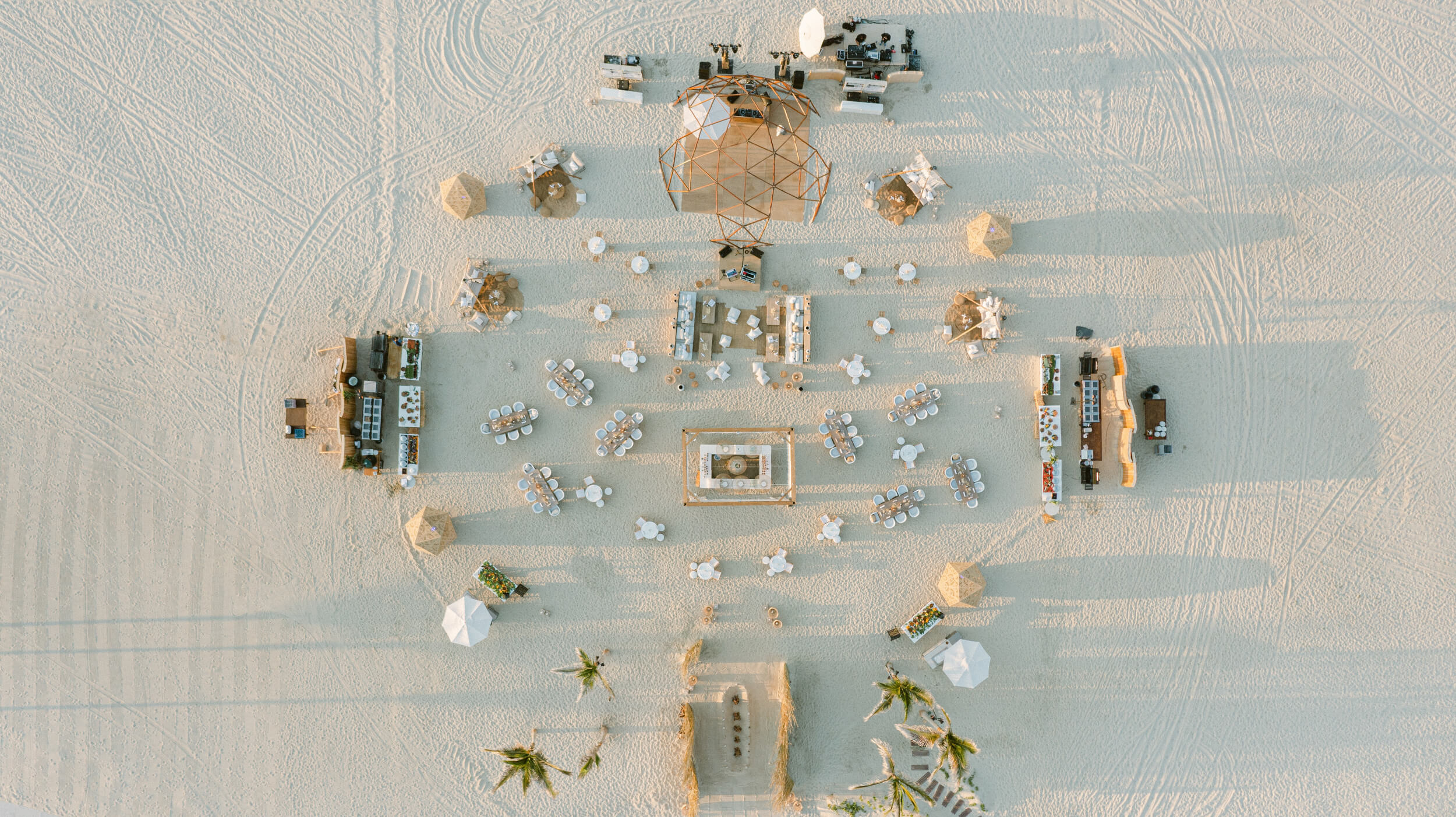 Aerial shot of a seating, dining, and bar areas on the sand