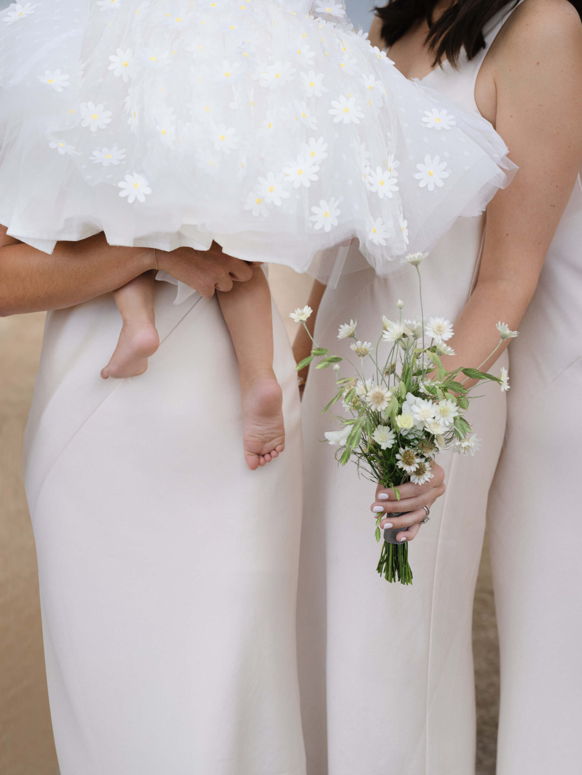 Bridesmaids holding a baby and flowers