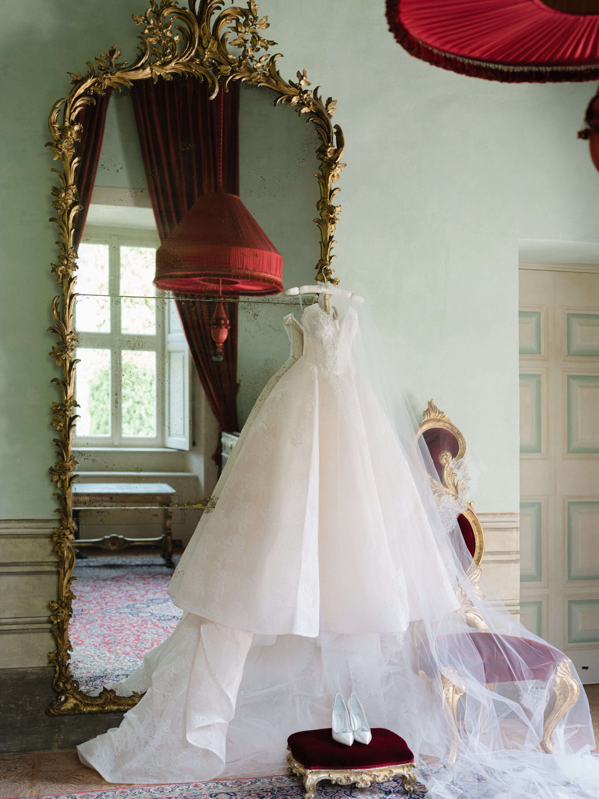 A Monique Lhuillier spring wedding gown hung up on an ornate mirror