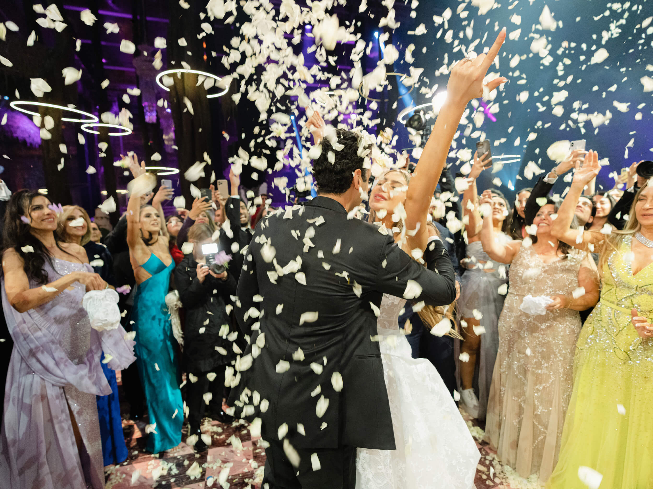 Ashley and Brian celebrating as guests cheer and flower petals fall from above