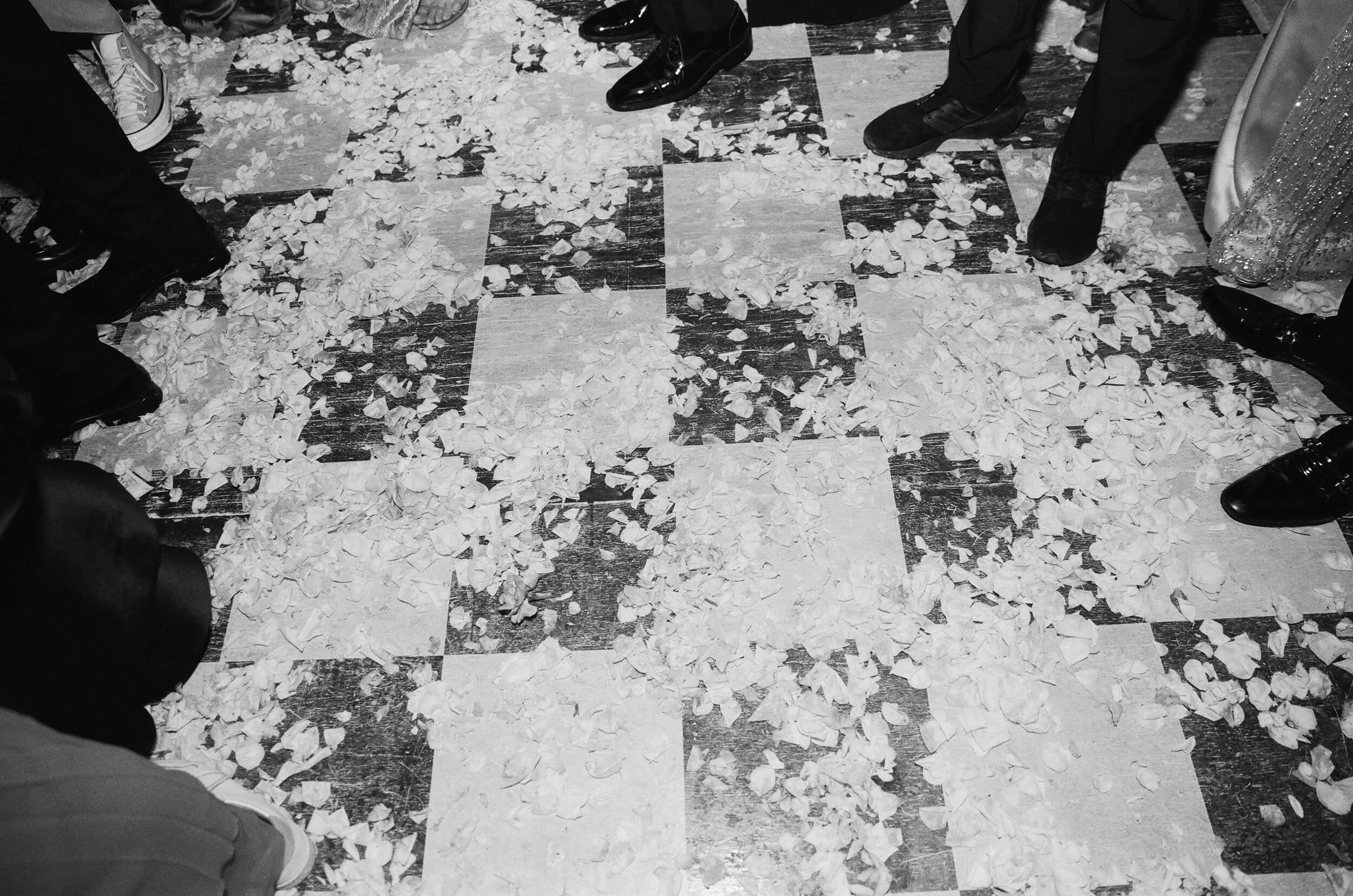 Black and white shot of flower petals on the dance floor