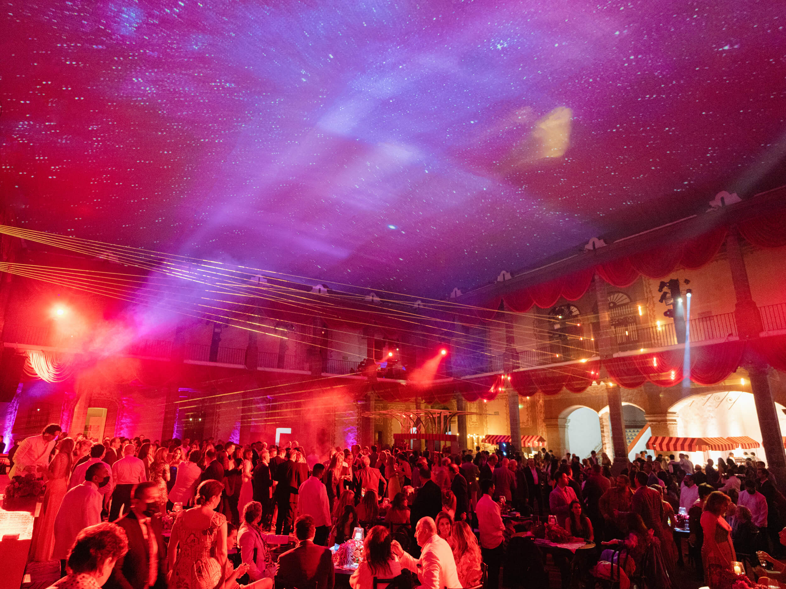 Guests celebrating under colorful lights and lasers