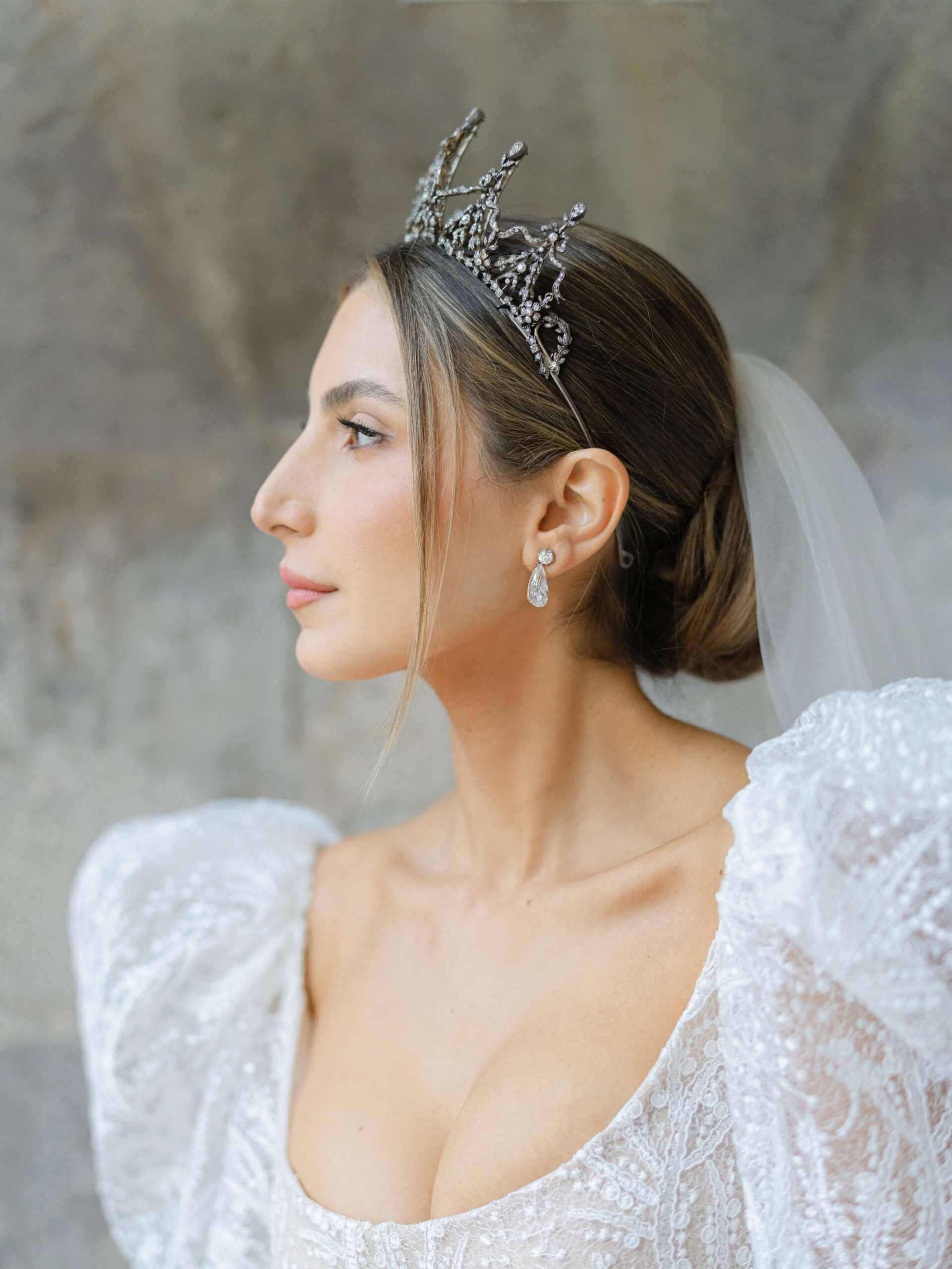 Side profile of Ashley wearing her Reem Acra wedding gown, vintage crown, and diamond raindrop earrings