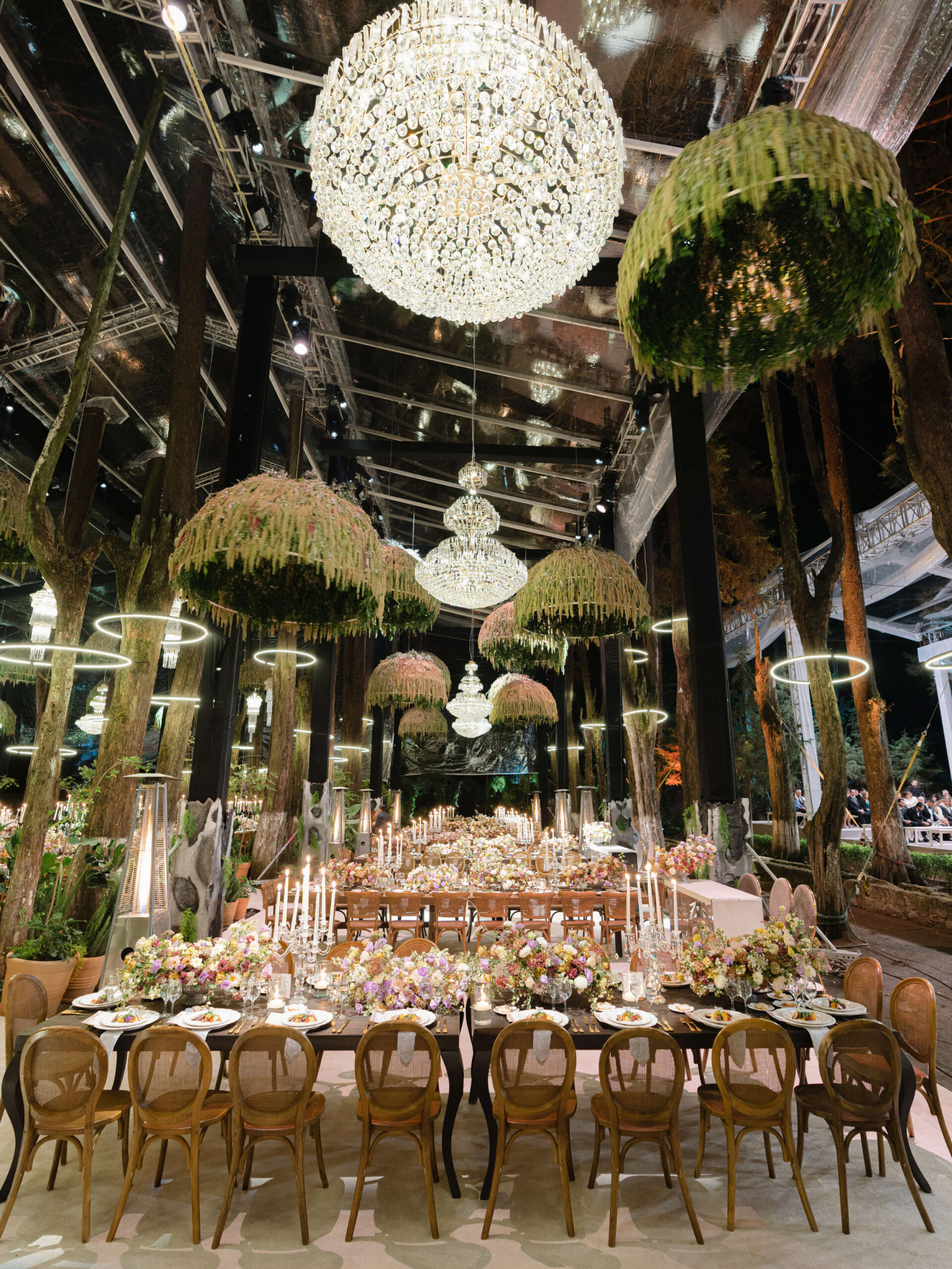 Forest wedding reception with custom moss and crystal chandeliers hanging from above