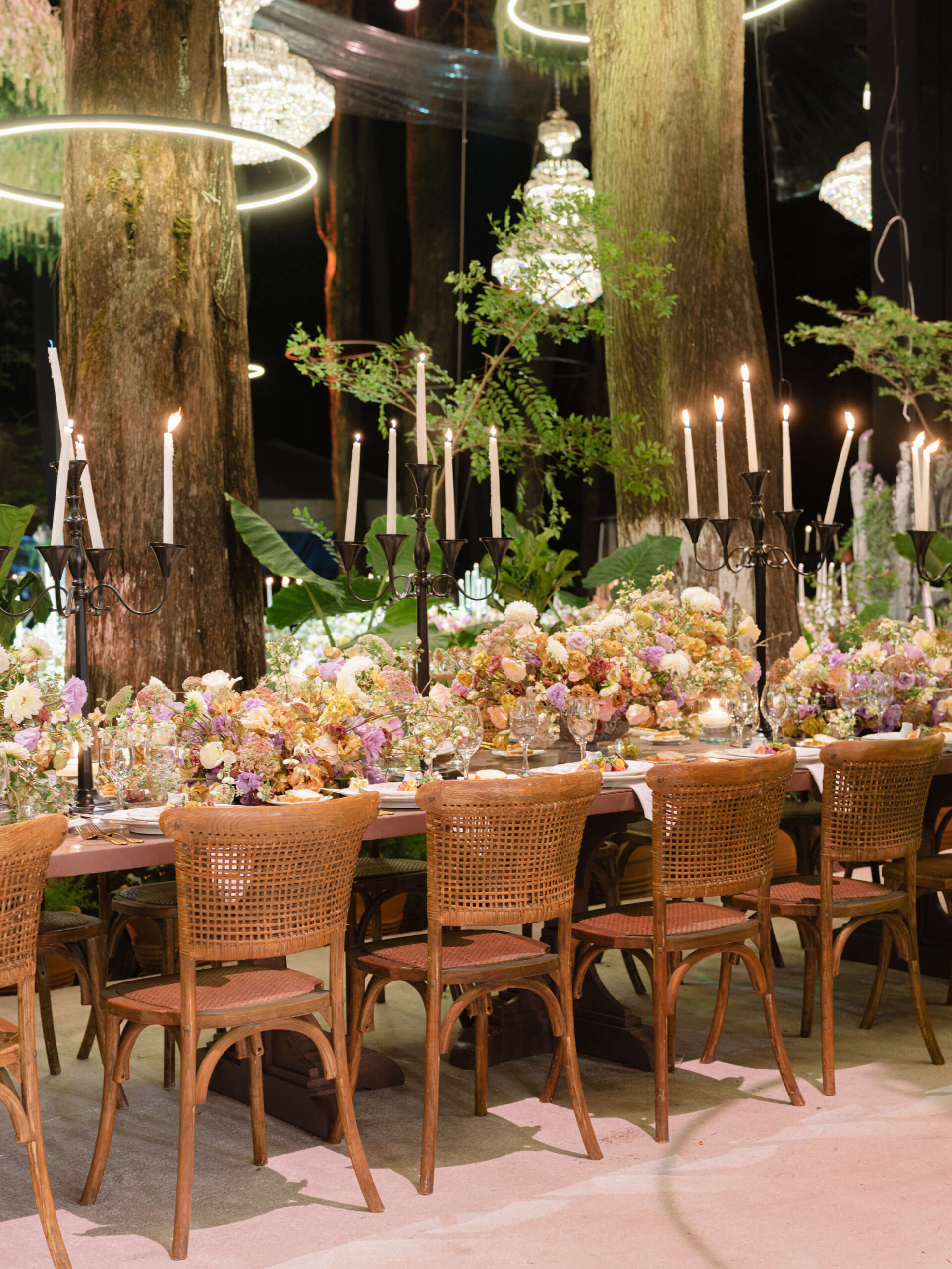 Reception design details; candelabras, flowers, chandeliers, and halo lights around the trees