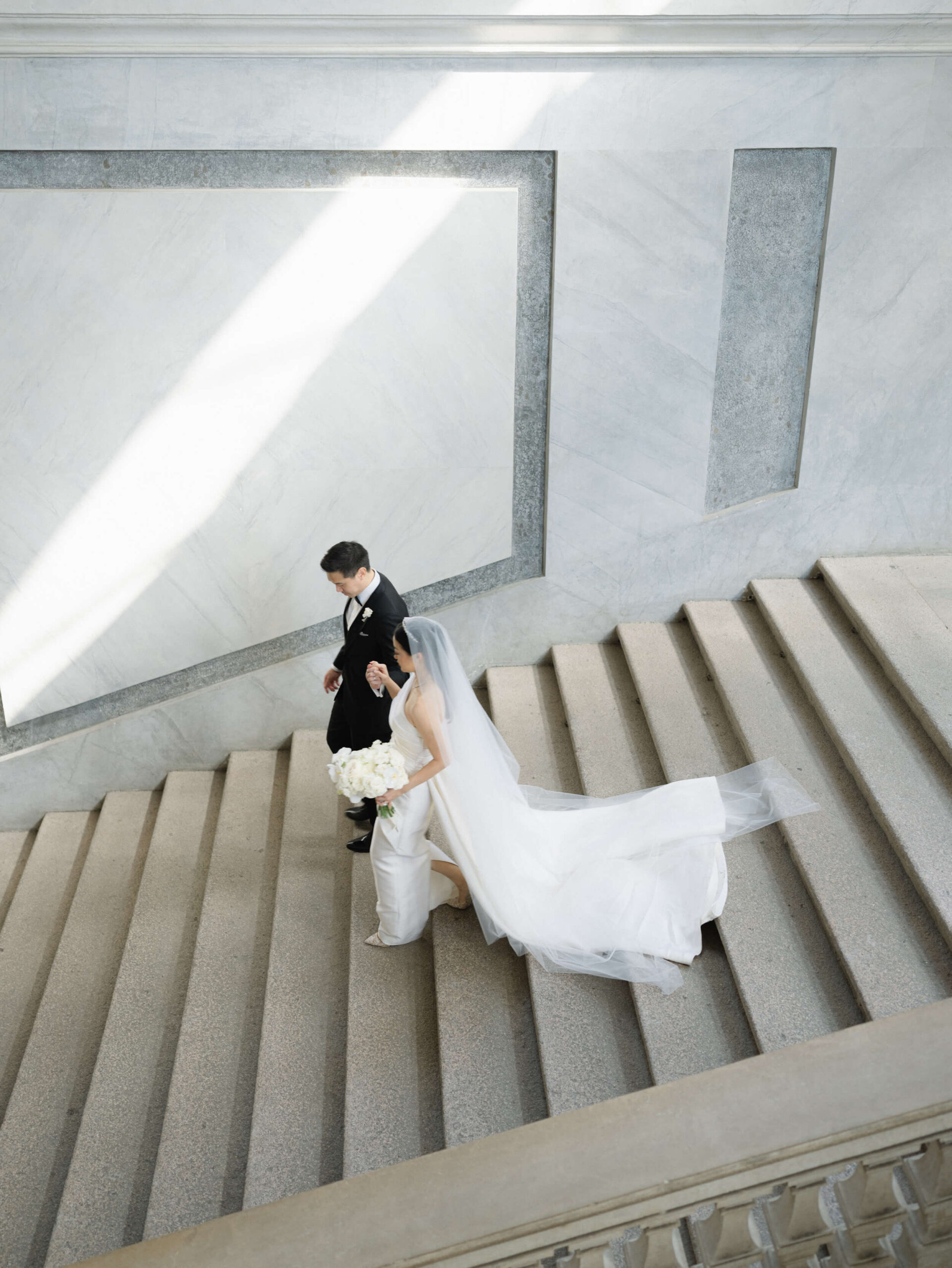 bride + groom walking down the steps of Chiesa di San Fedele