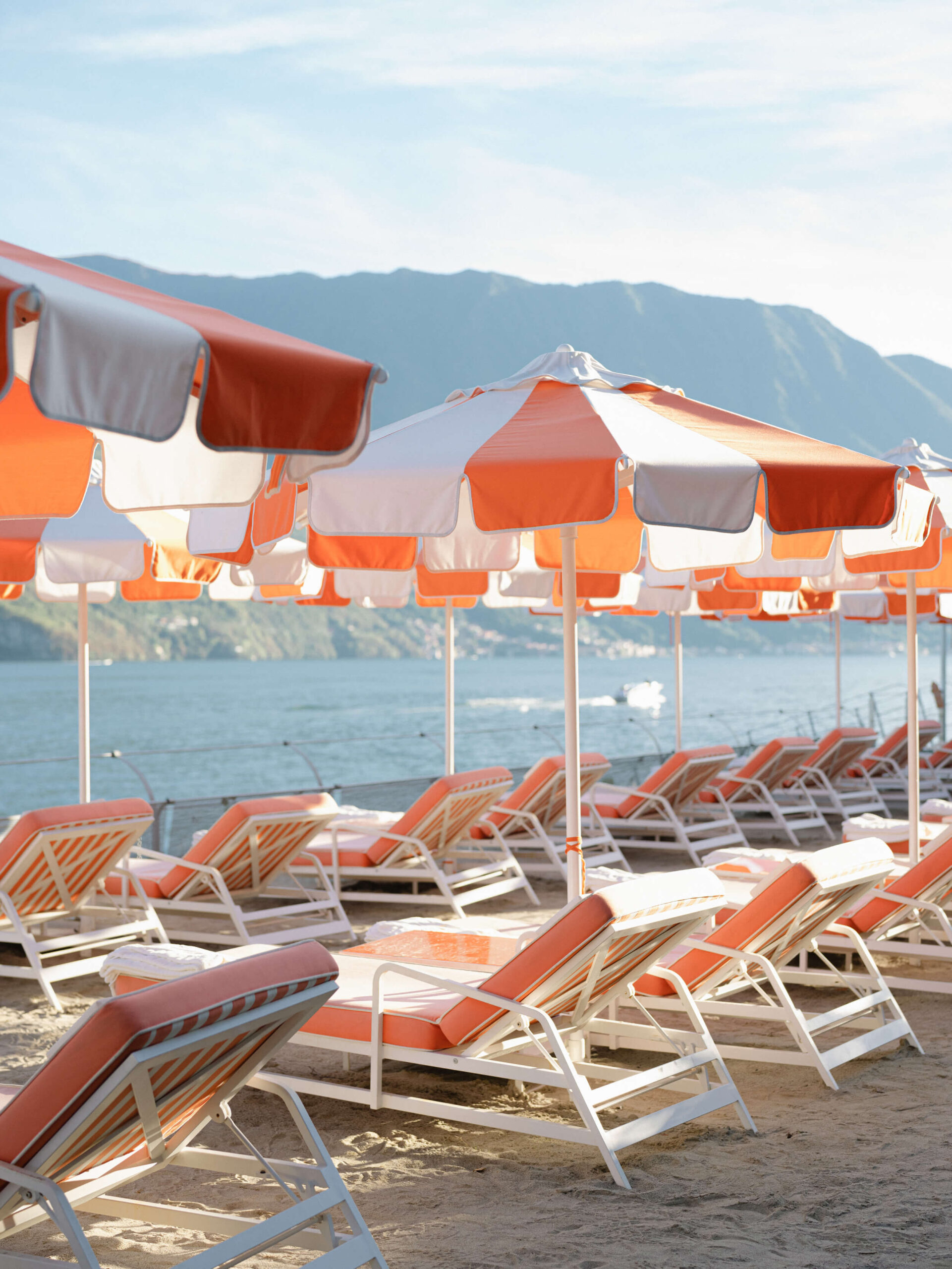 Chaise lounges and umbrellas lining Lake Como