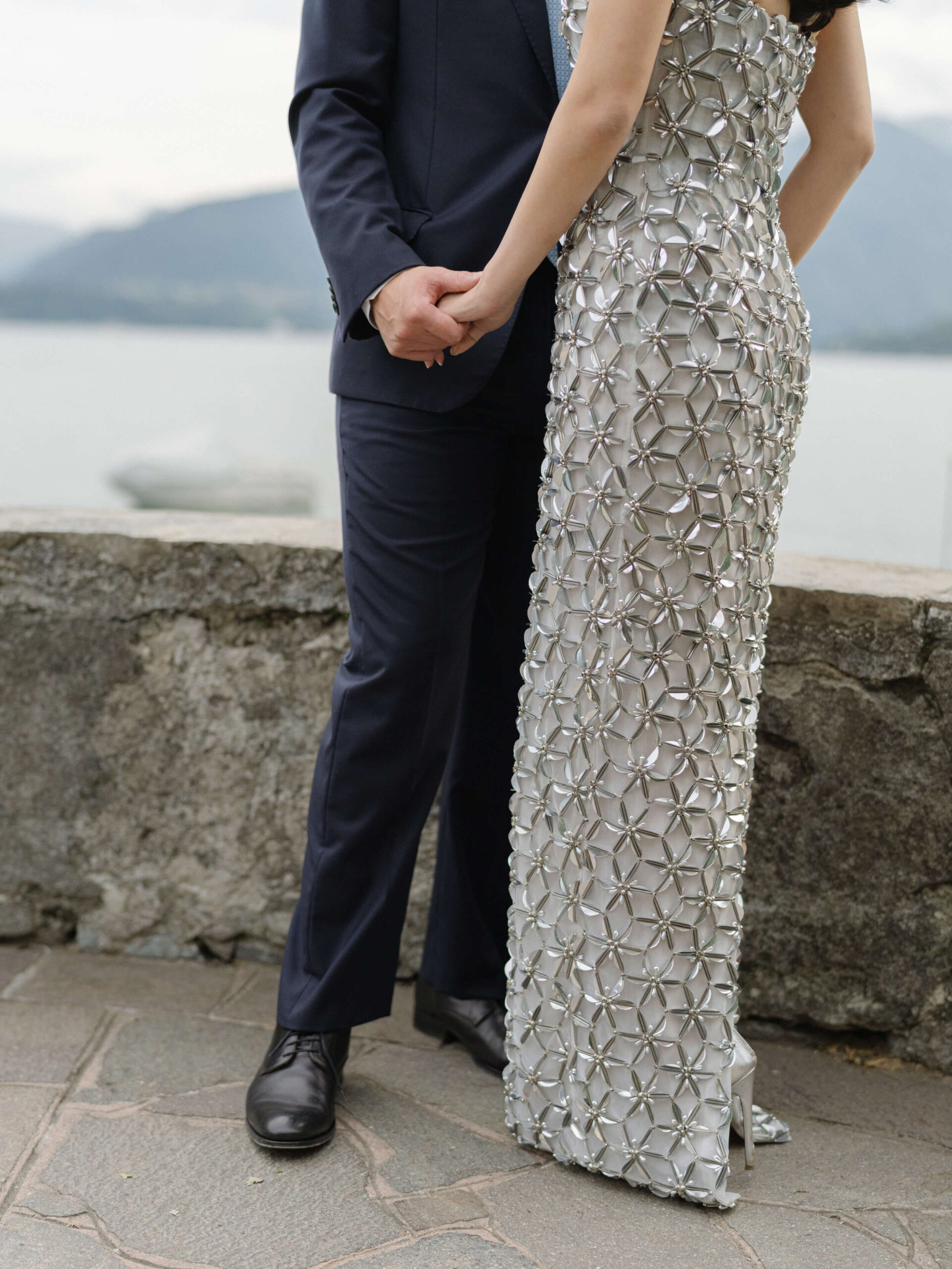 K + J holding hands; Lake Como in the background