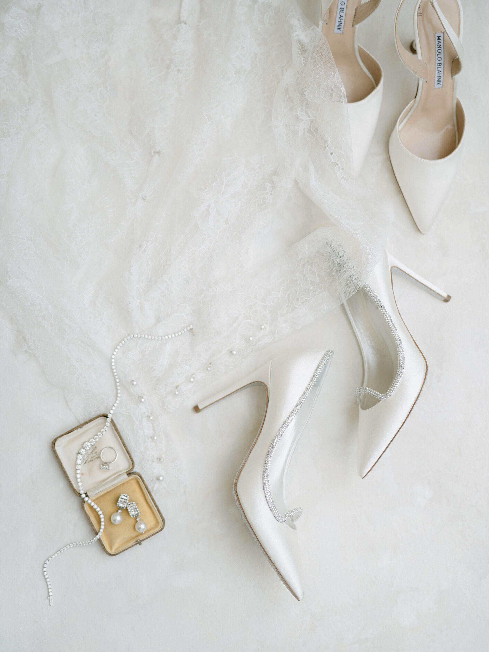 Flatlay of bride's shoes, veil, and jewelry