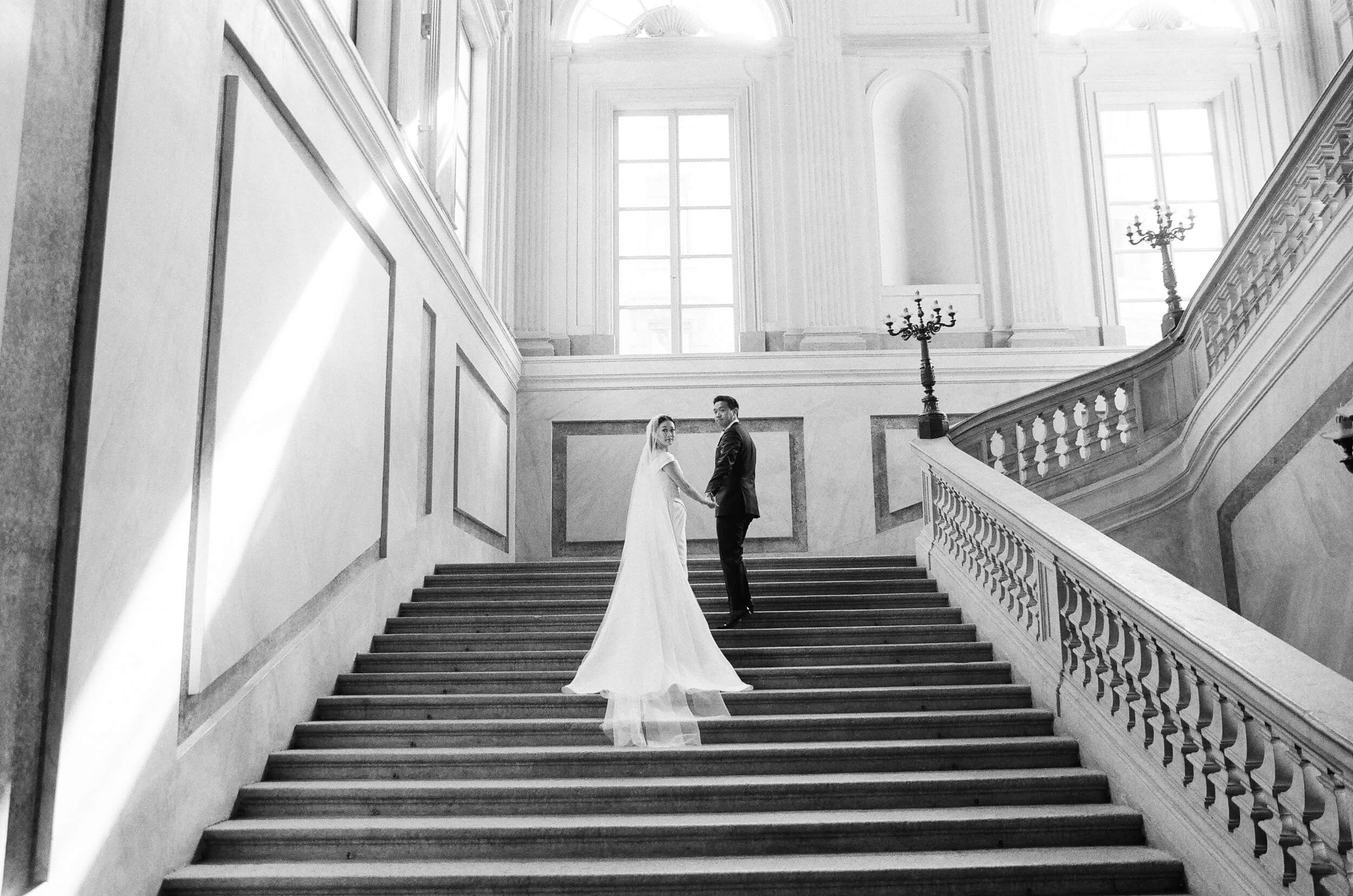 Bride and groom at the colossal staircase of  Chiesa di San Fedele